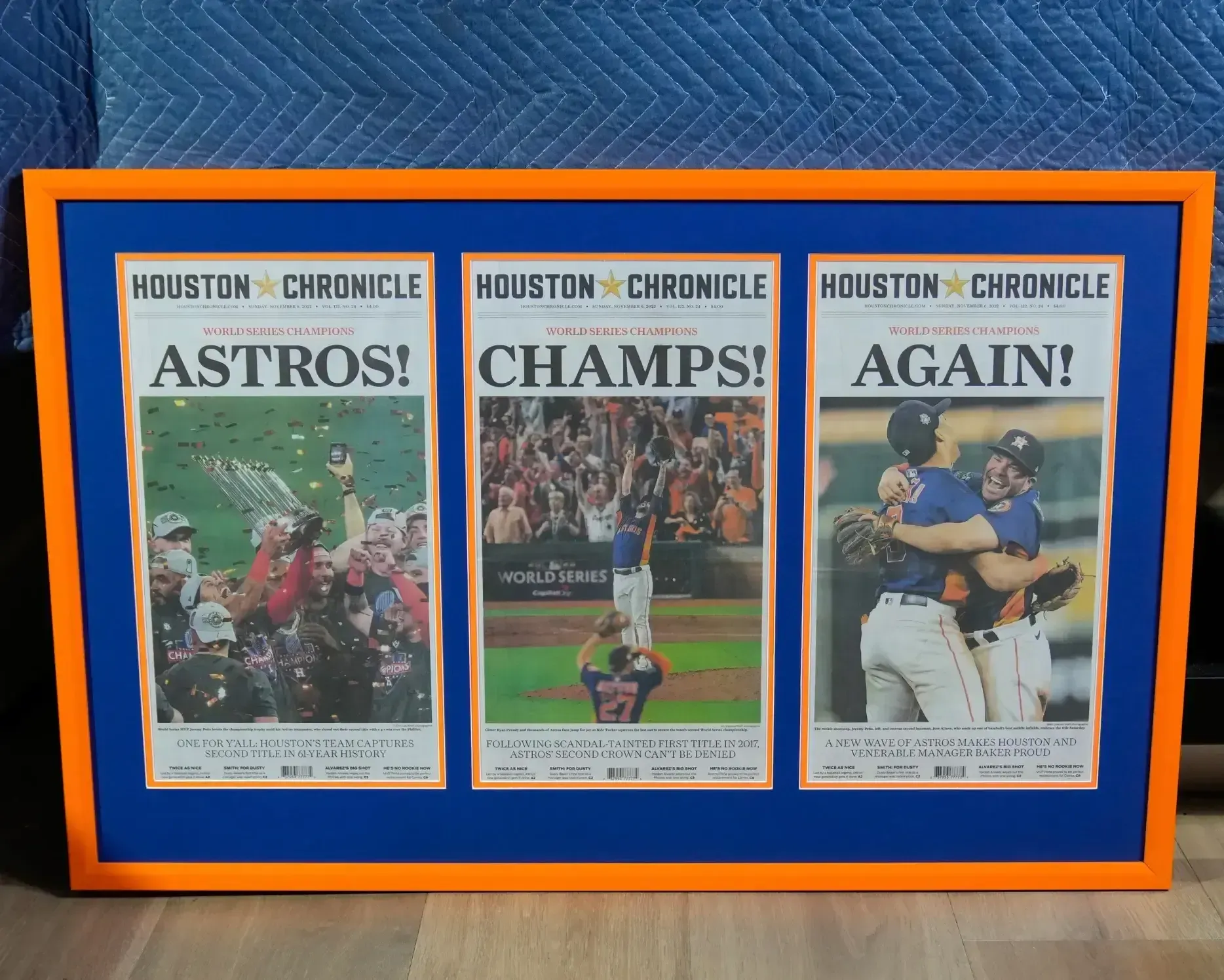 Framed Houston Chronicle Astros championship newspaper front pages on a blue mat with orange border