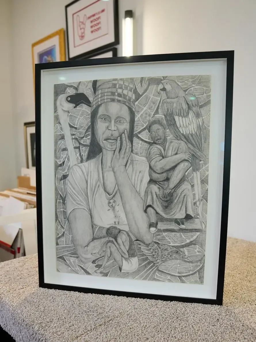 Framed black-and-white sketch of a person in a thoughtful pose, leaning on a hand.