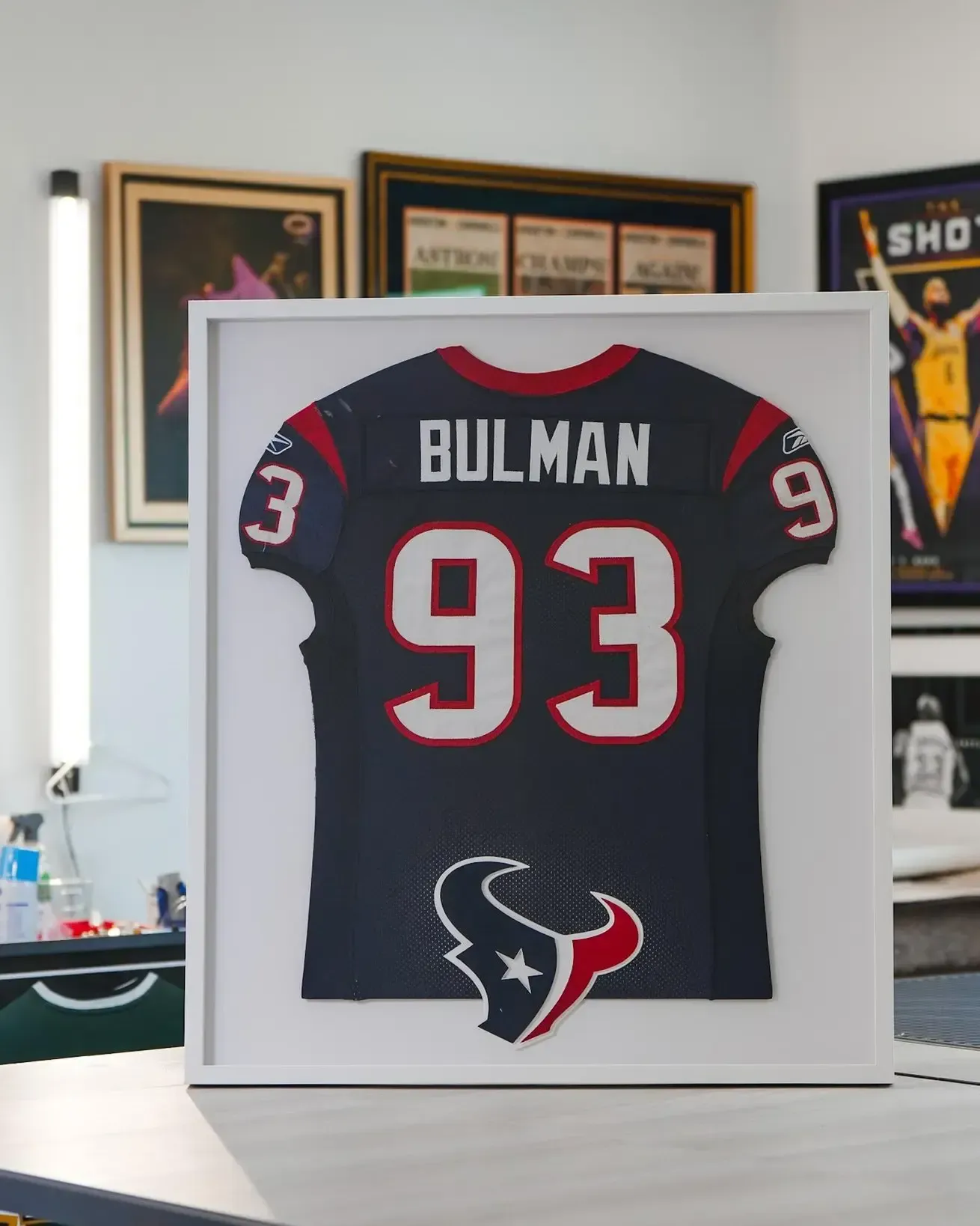 Framed Bulman #93 Houston Texans jersey on display in a white shadow box