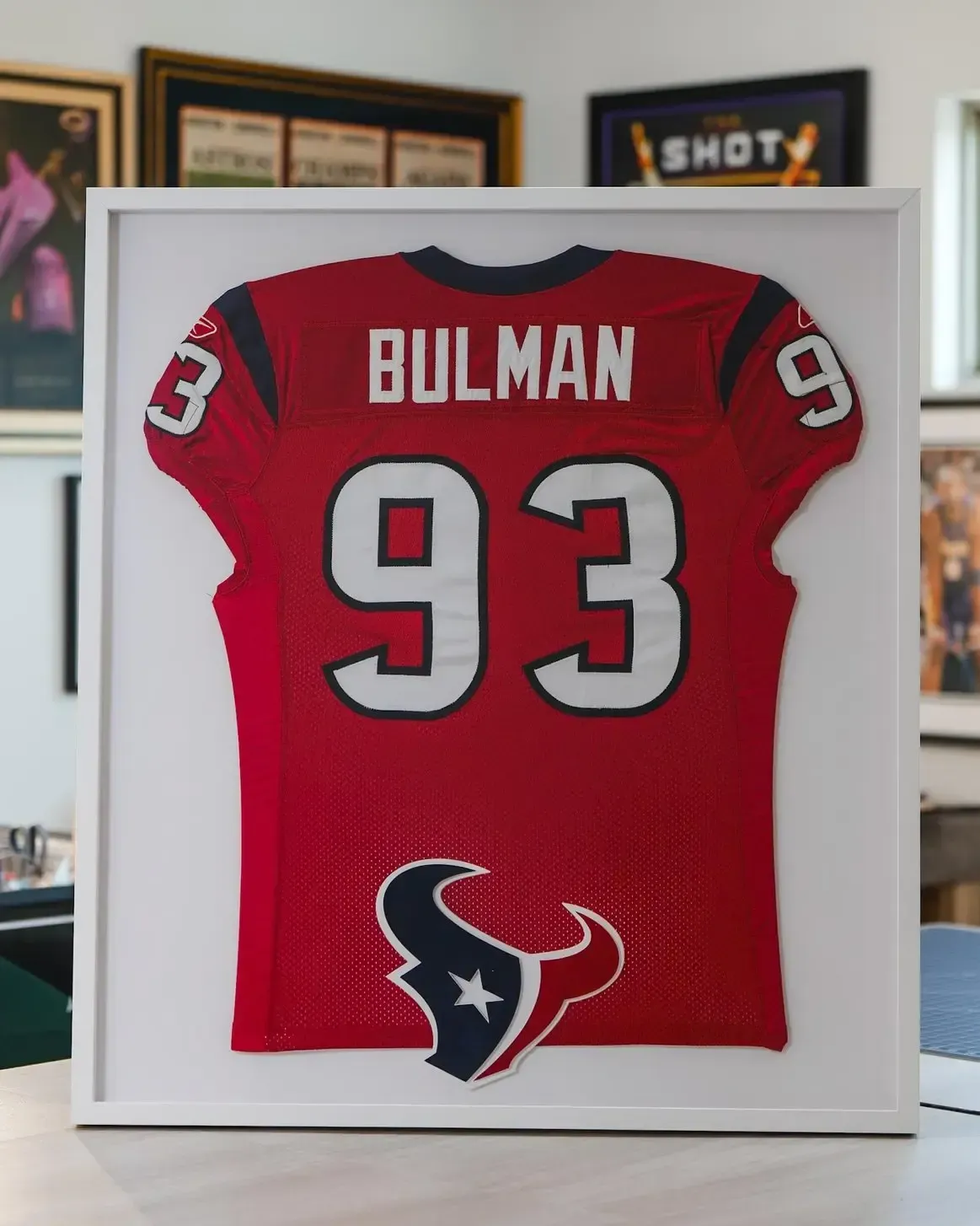 Framed red Houston Texans jersey with name BULLMAN and number 93 on display