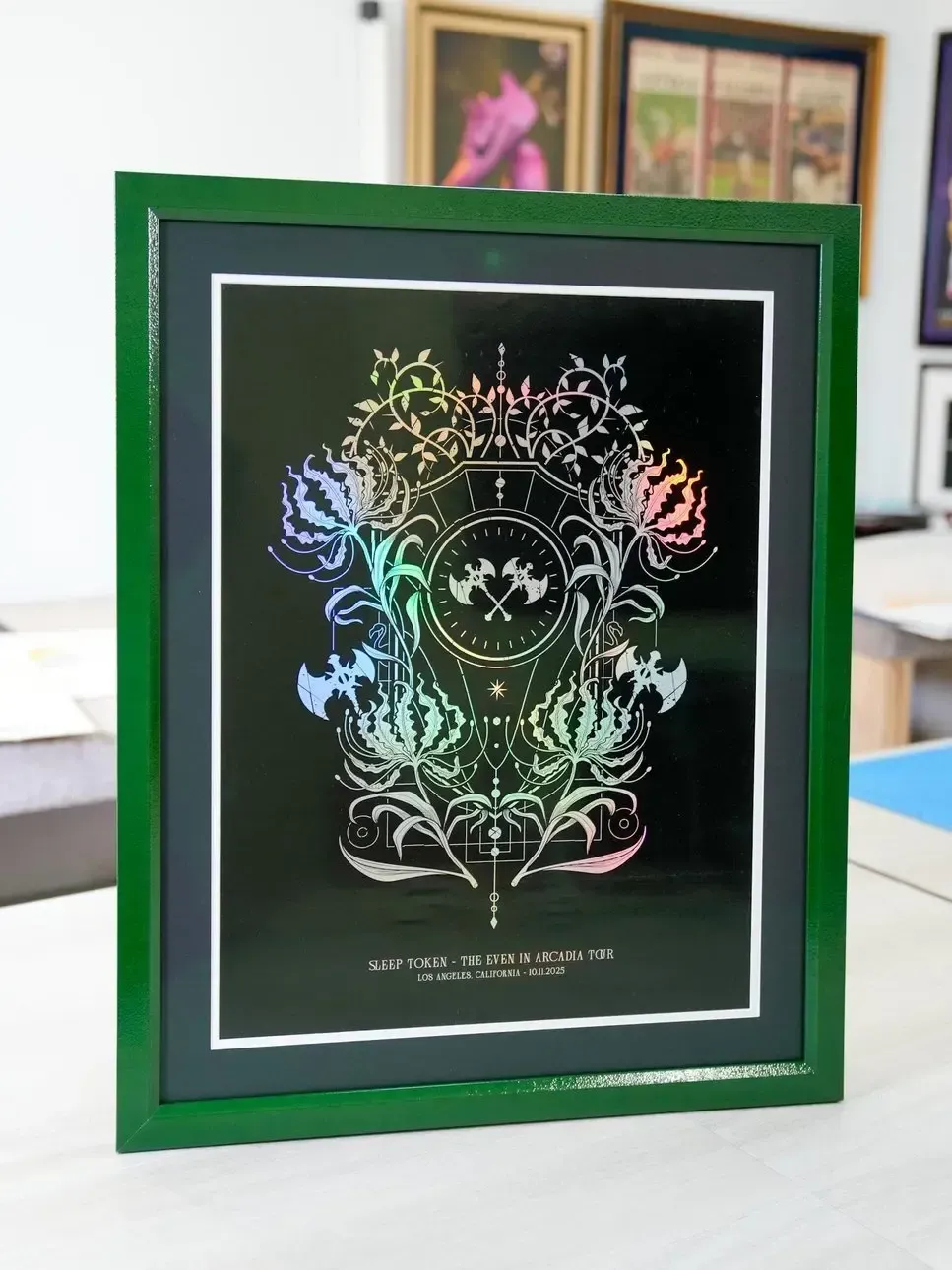 Framed colorful abstract floral artwork on a black background in a green frame
