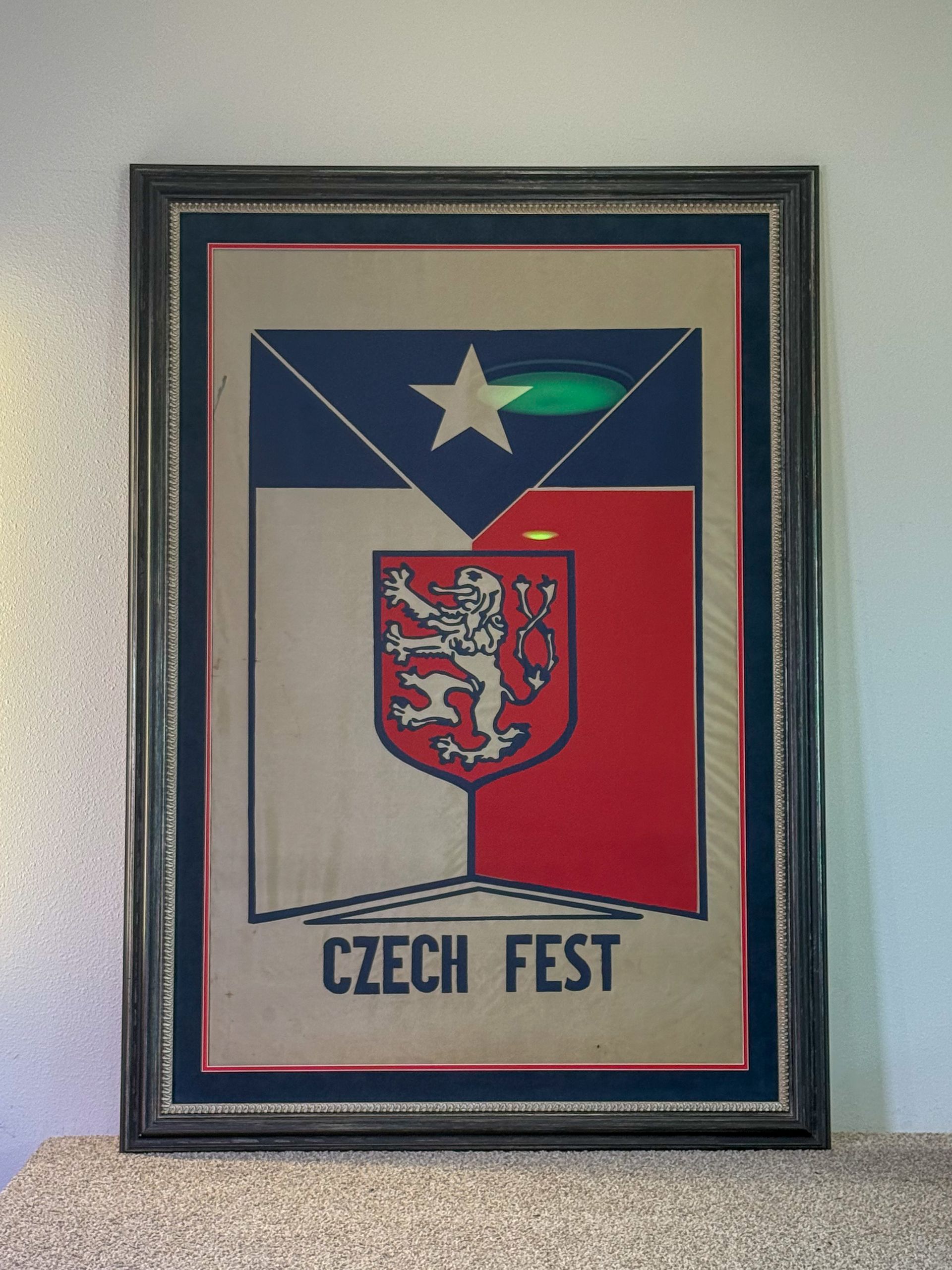 Framed Czech Fest poster with Czech colors and coat of arms hanging on a wall
