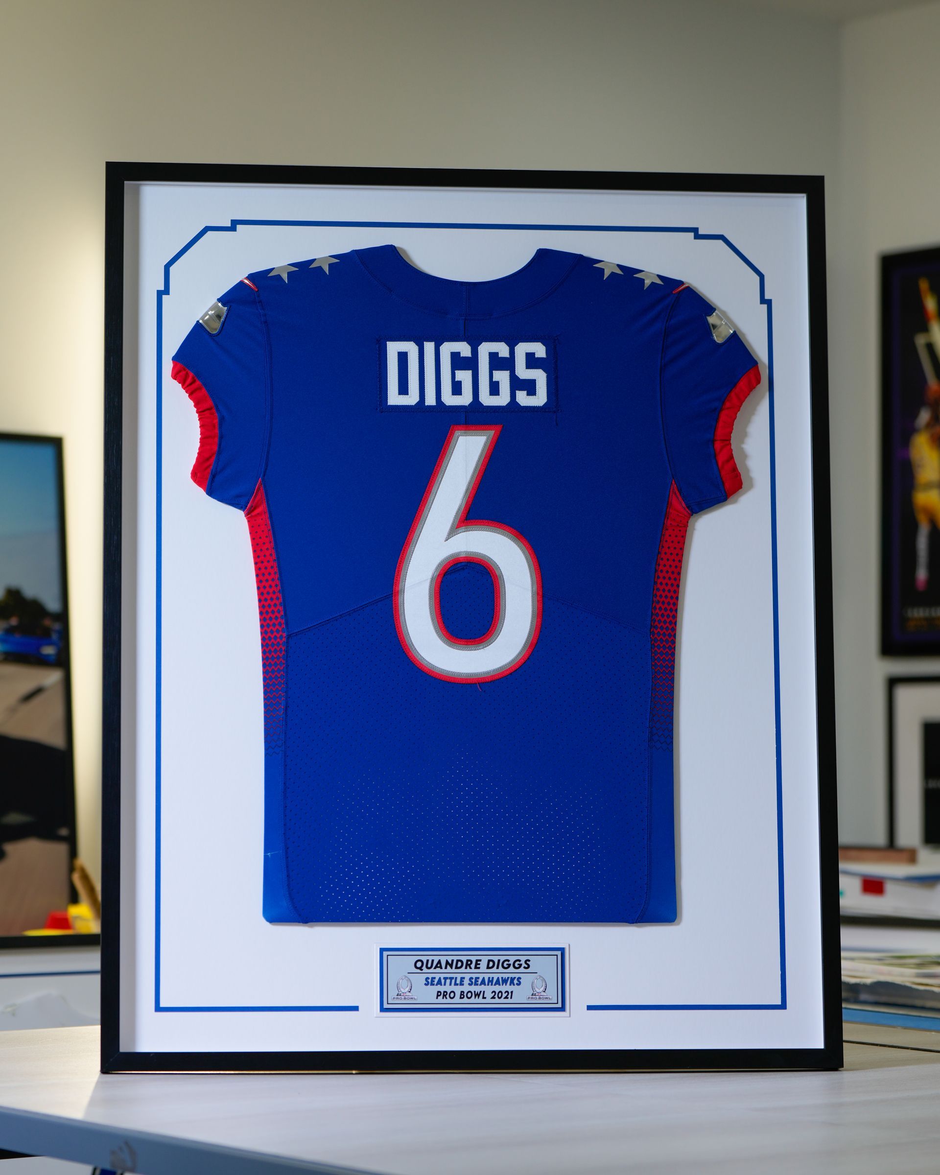 Framed blue football jersey with white number 6 and “DIGGS” on the back