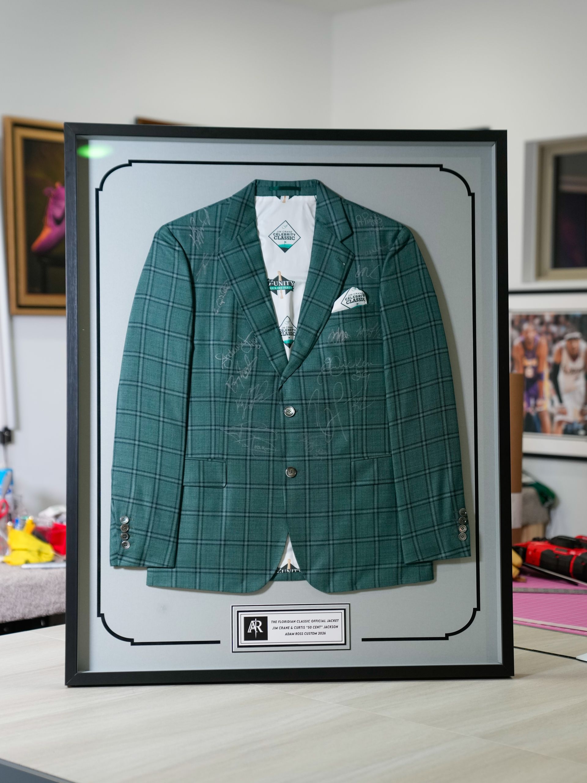 Framed green plaid suit jacket displayed on a tabletop