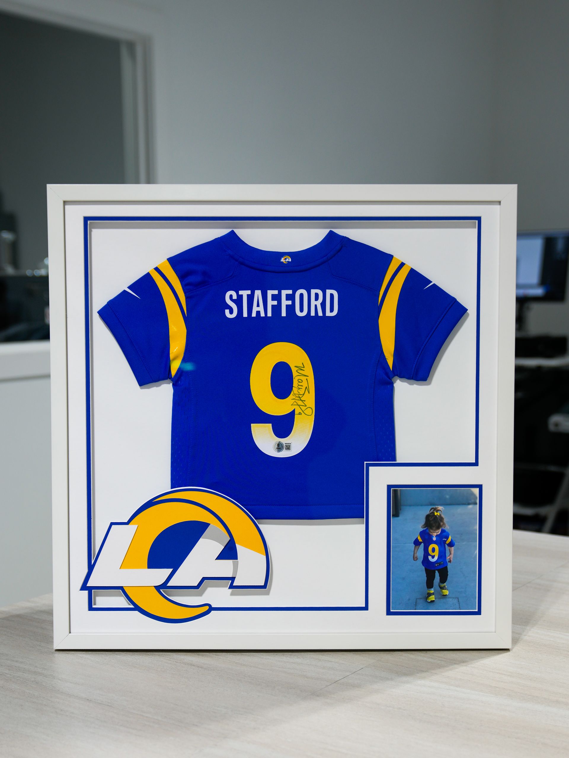Framed Los Angeles Rams Stafford #9 jersey display with small action photo and team logo