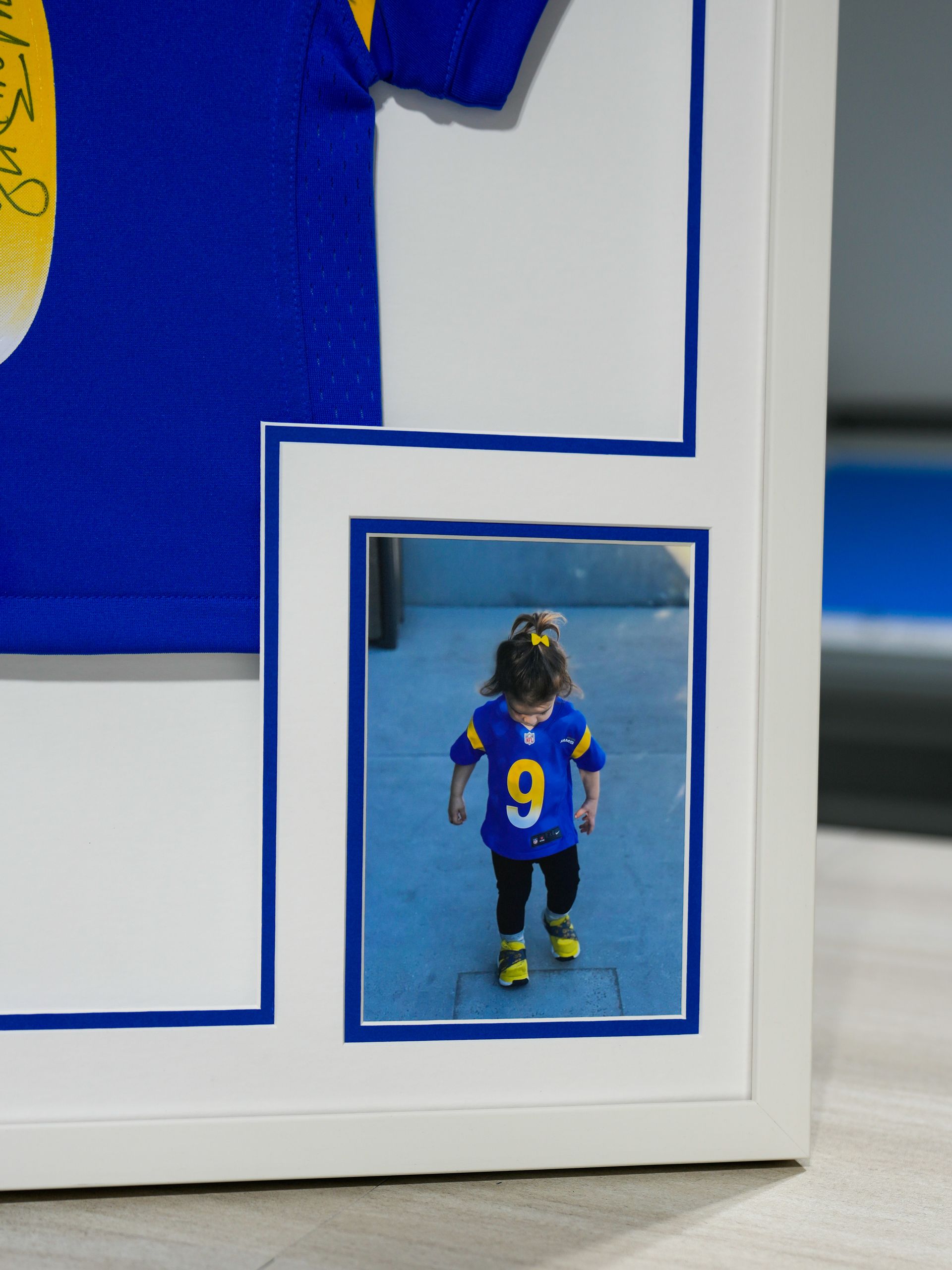 Blue-and-yellow soccer player figurine with number 9 in a framed display