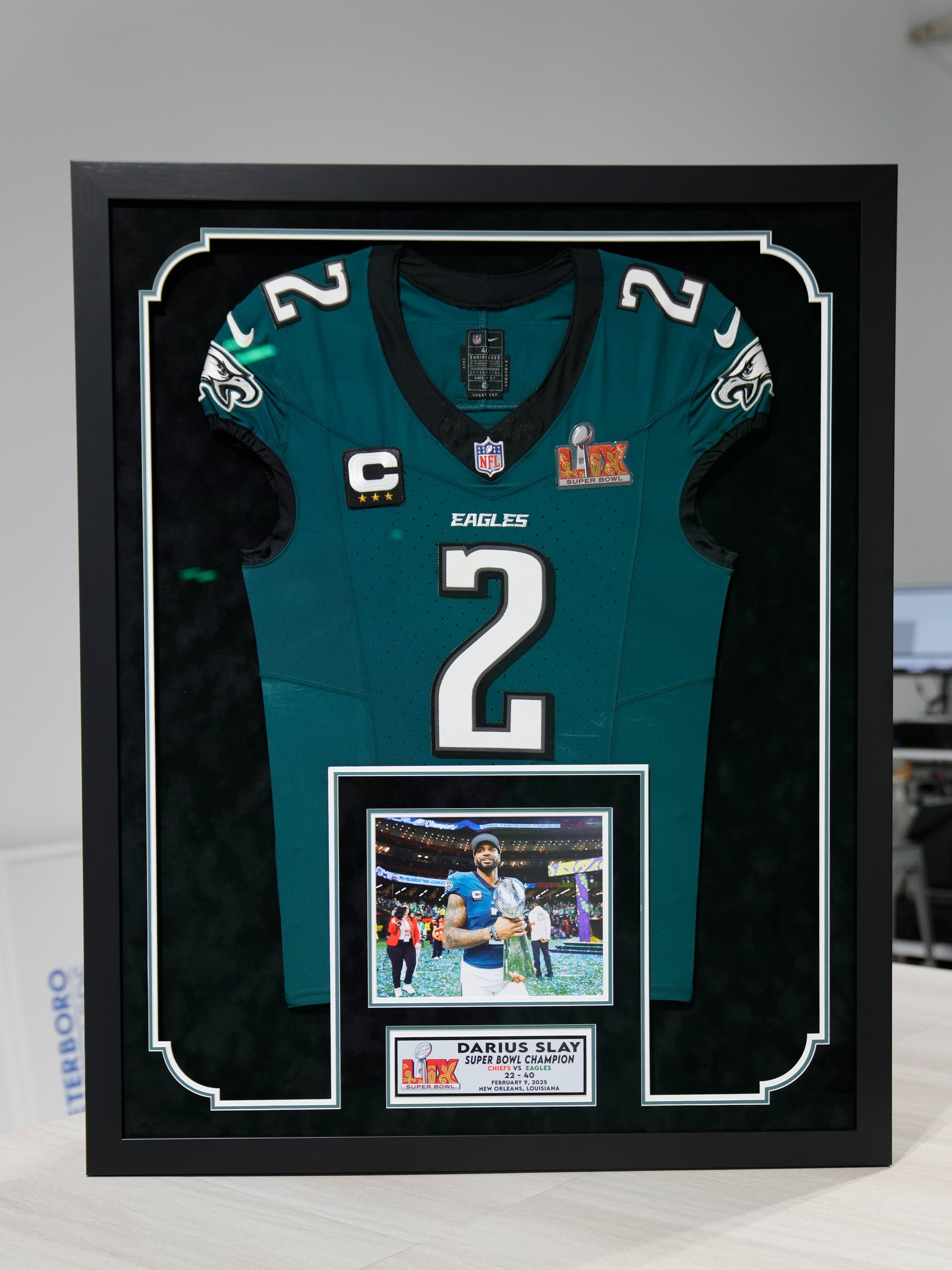 Framed teal football jersey with number 2 and a small action photo at the bottom