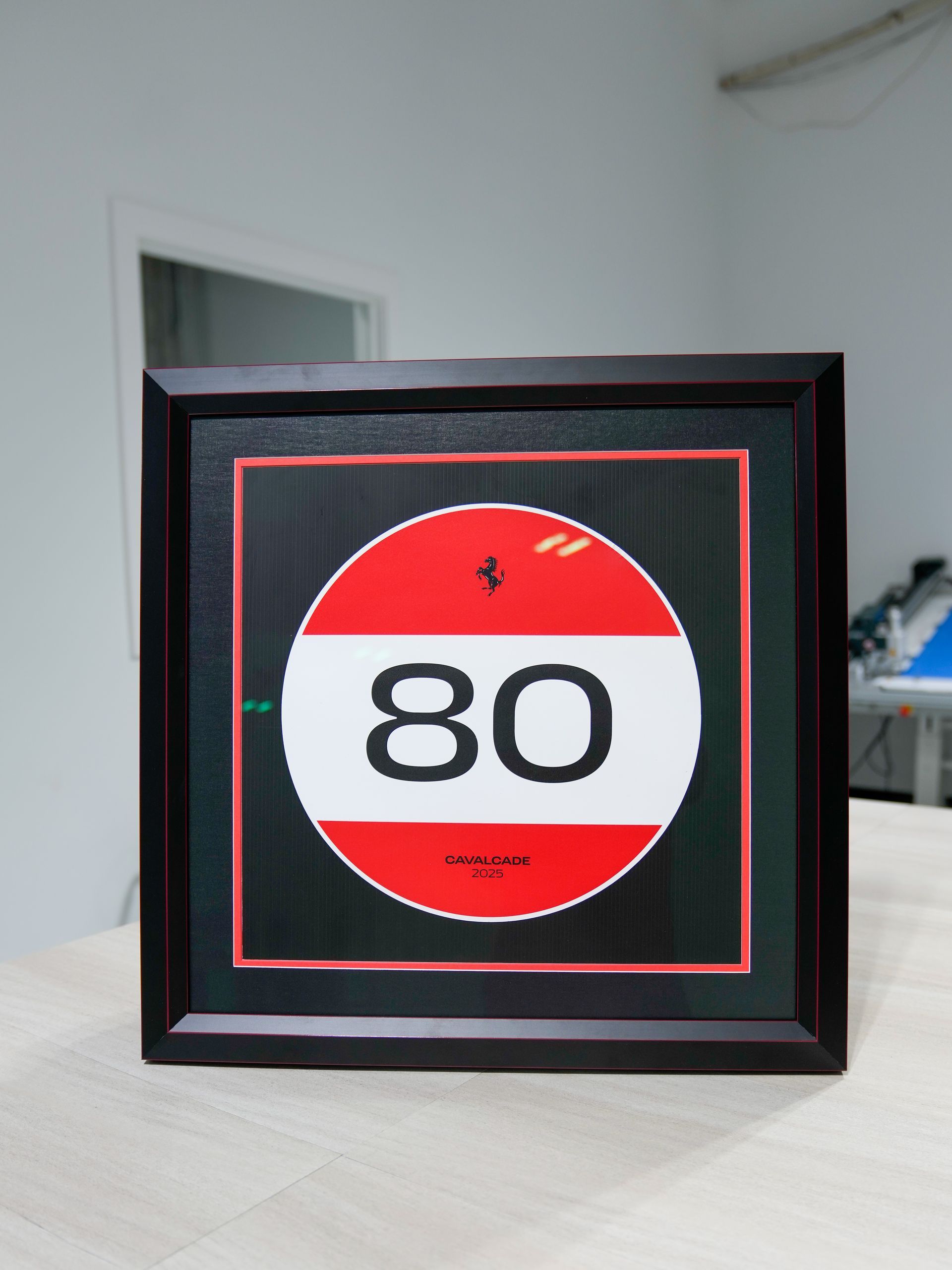 Framed red and white 80 speed limit sign on a shelf in a room