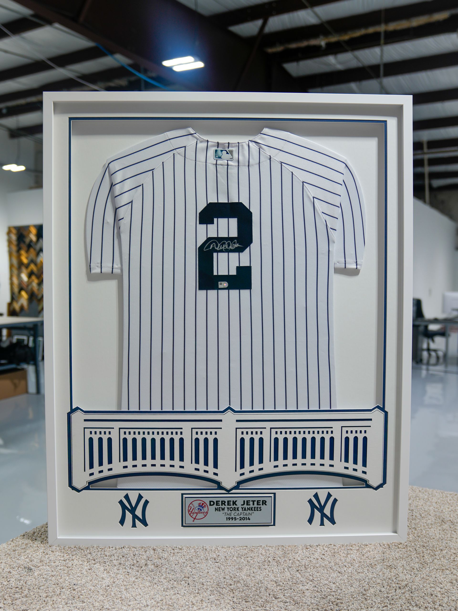 Framed New York Yankees pinstriped jersey display with number 2 and team logos