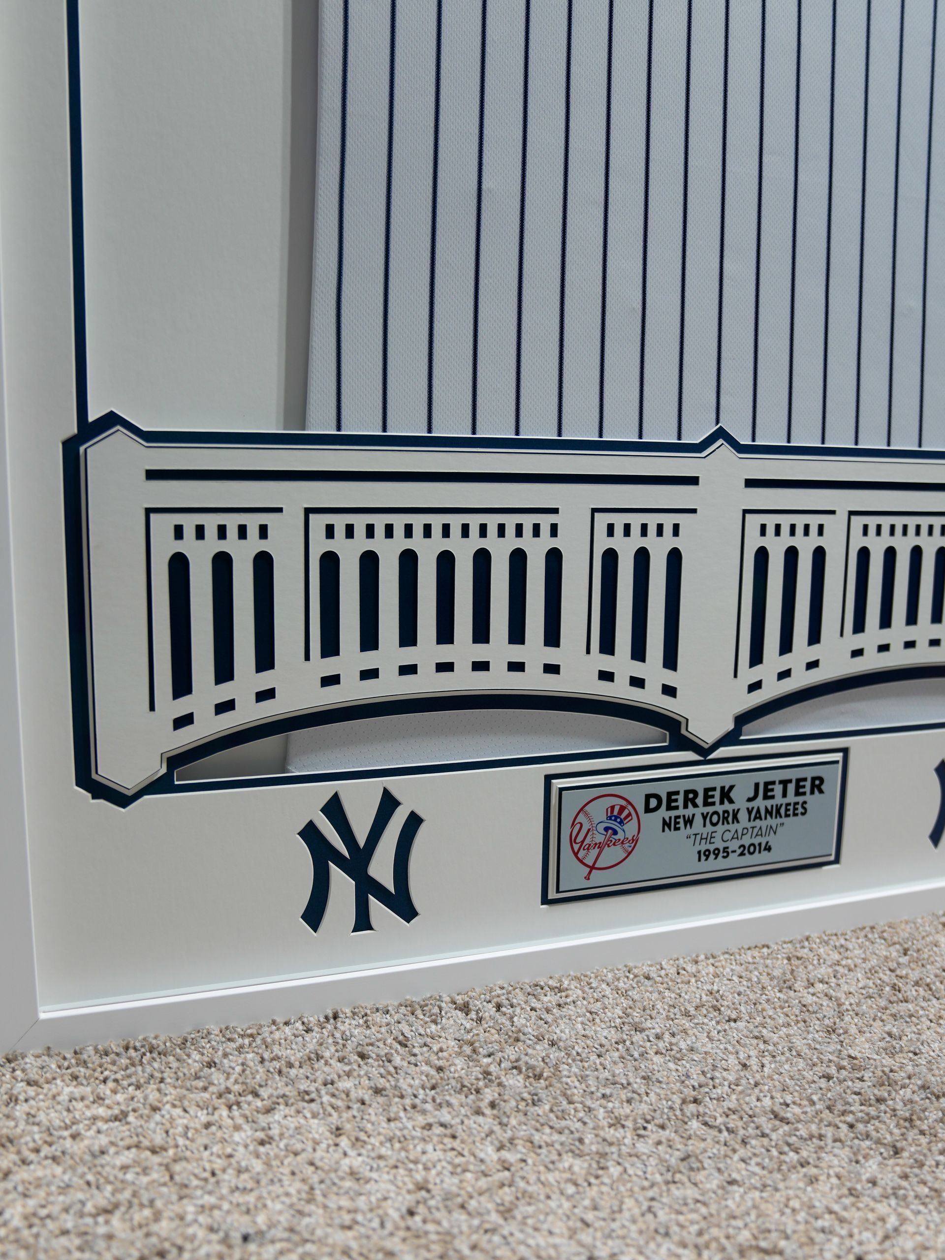 Hand-drawn Yankees stadium wall with railing, NY logo, and a small plaque on a light background