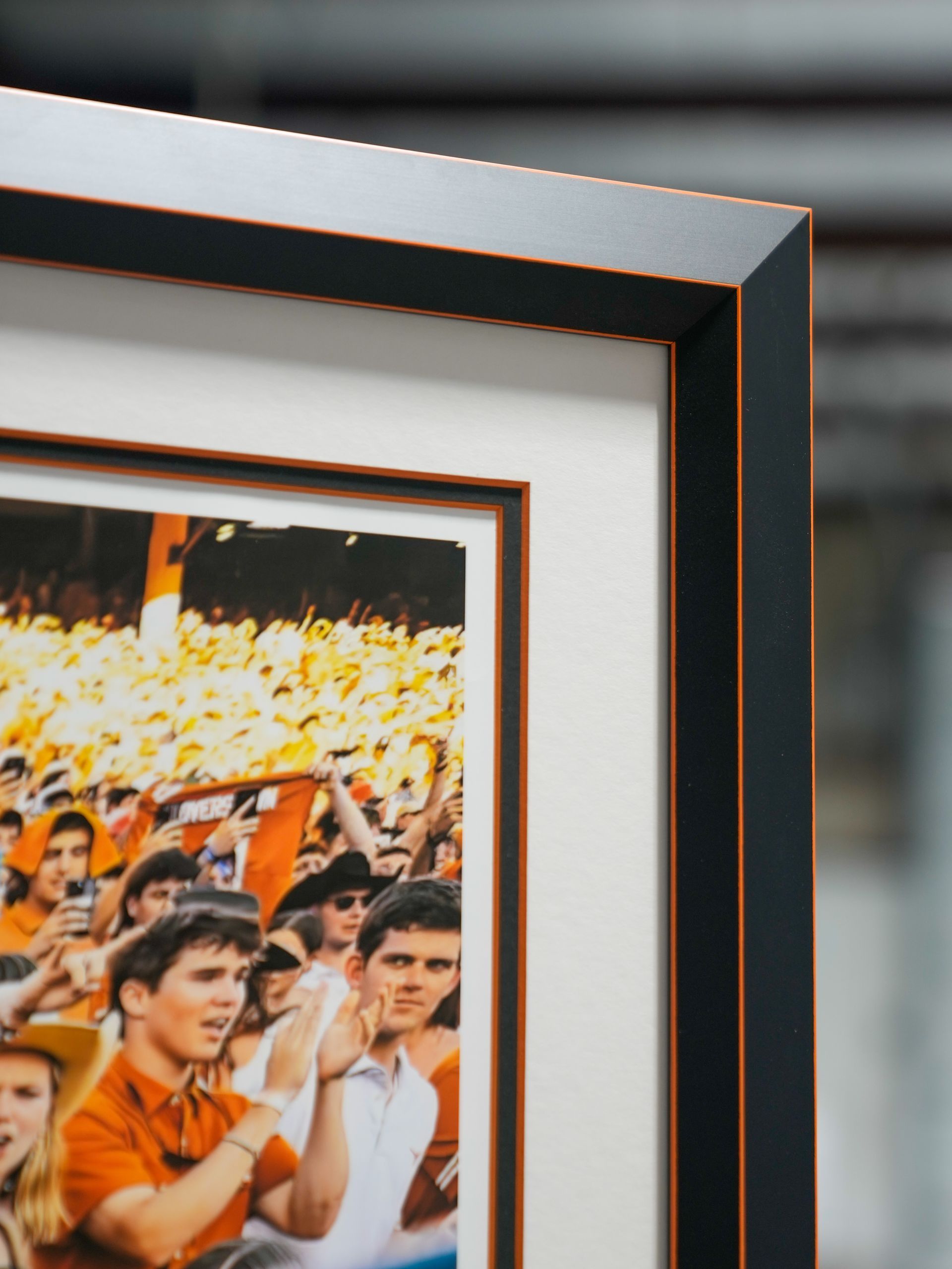 Framed photo of a crowd cheering in orange shirts at an outdoor event