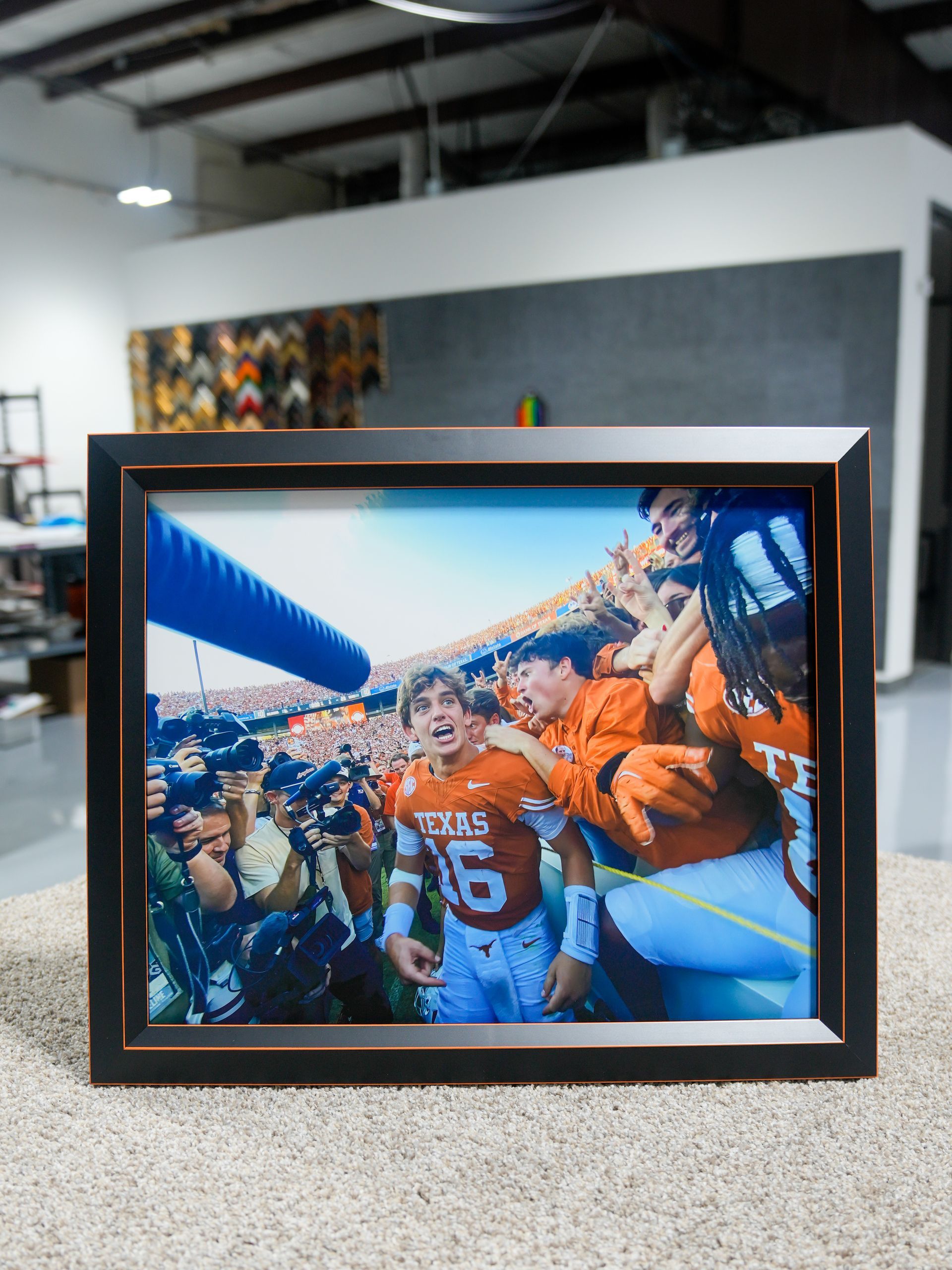 Framed photo of cheering football fans in orange jerseys at a stadium entrance