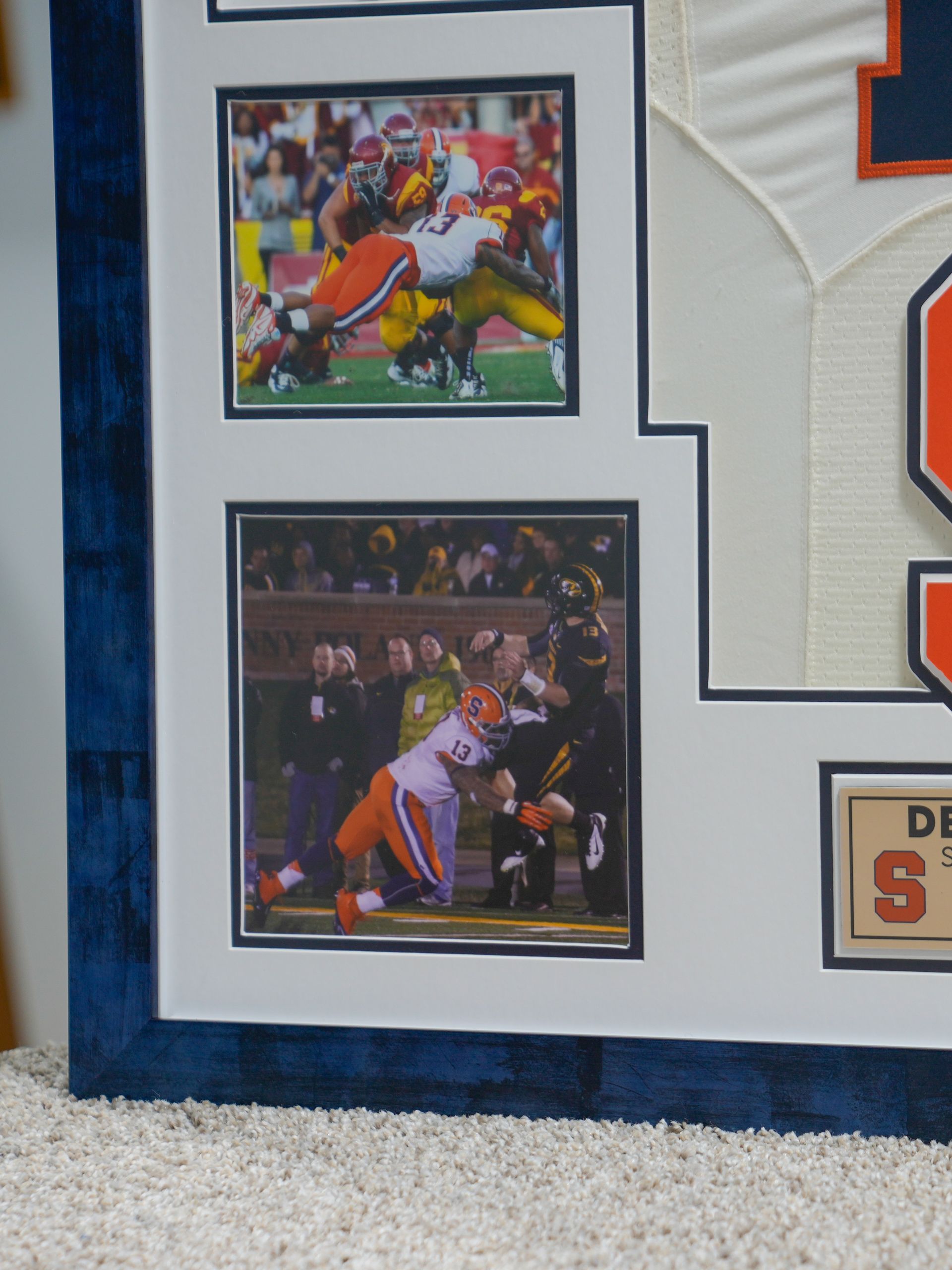 Framed football action photos on a wall, with a blue border and white matting.