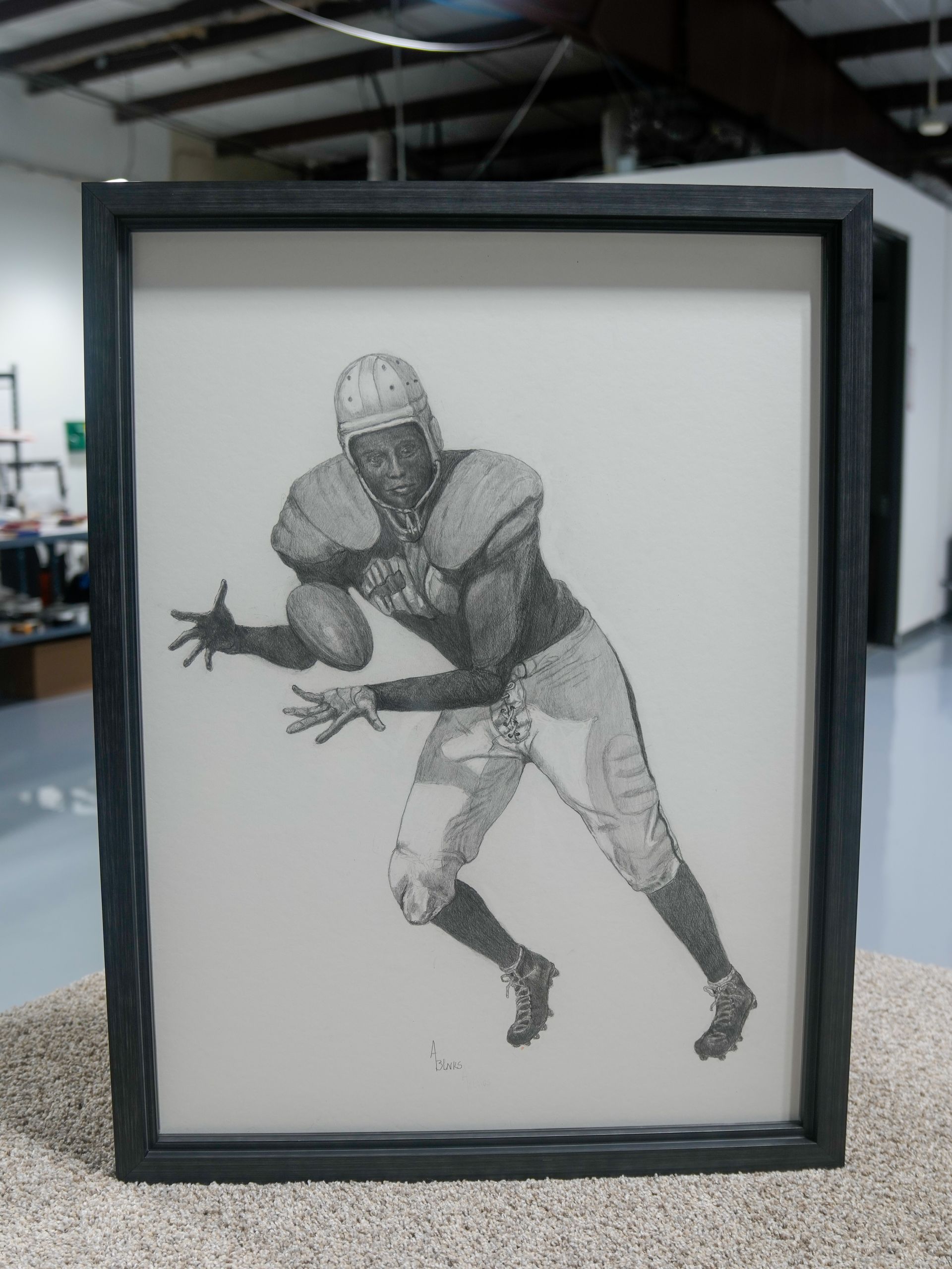 Framed black-and-white drawing of a football player in a crouched, ready-to-catch pose