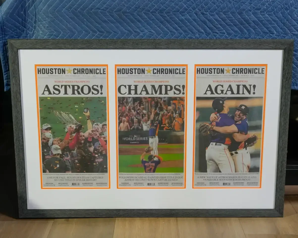 Framed Houston Chronicle sports front pages celebrating Astros championships on a wall.