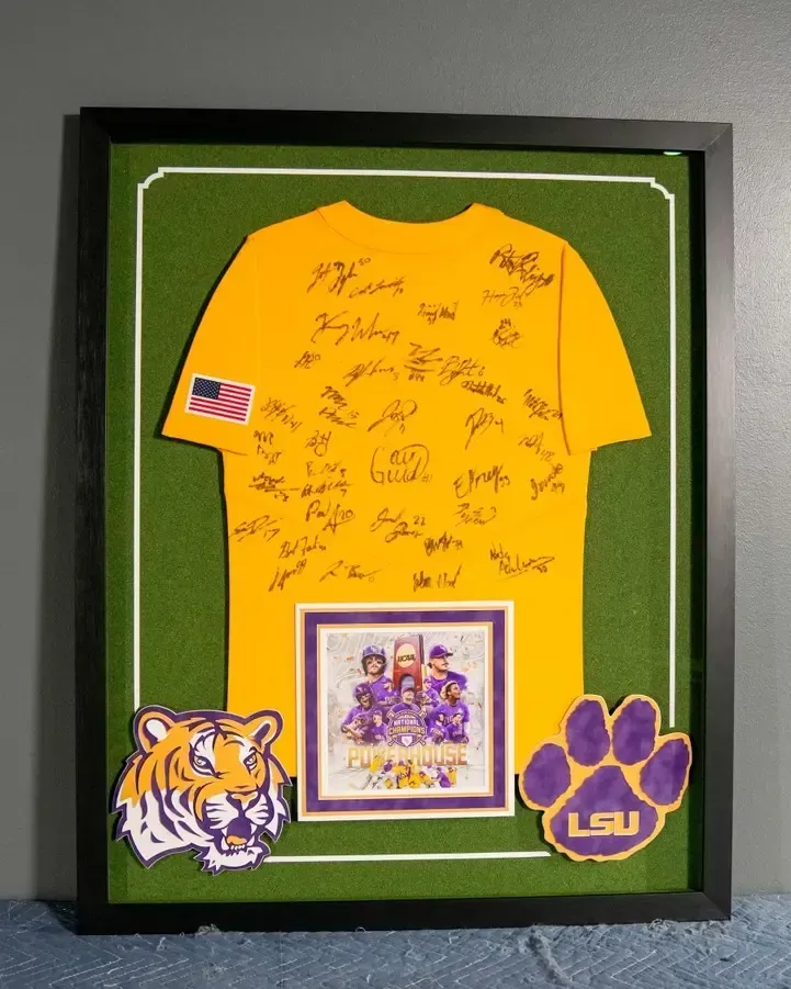 Framed green LSU jersey collage with signatures, tiger logo, and LSU paw patches