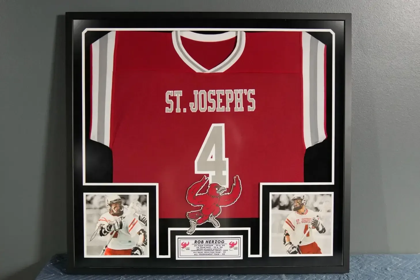 Framed St. Joseph’s red jersey with number 4 and two hockey action photos