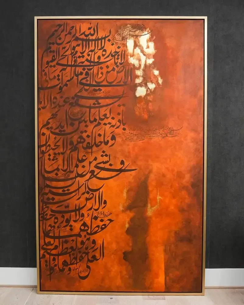 Orange abstract calligraphy painting with black Arabic script on a framed canvas