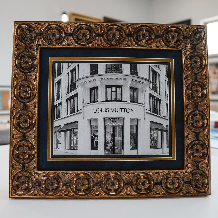 Framed black-and-white Louis Vuitton storefront sketch in an ornate gold frame