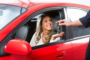 Man giving the key of a car to a woman