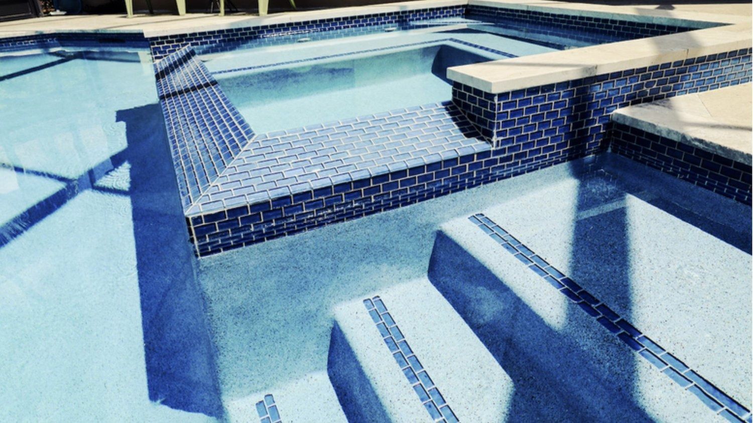 A large swimming pool with blue tiles and stairs