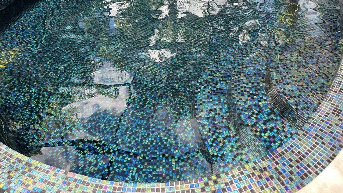 A close up of a swimming pool with a mosaic border.