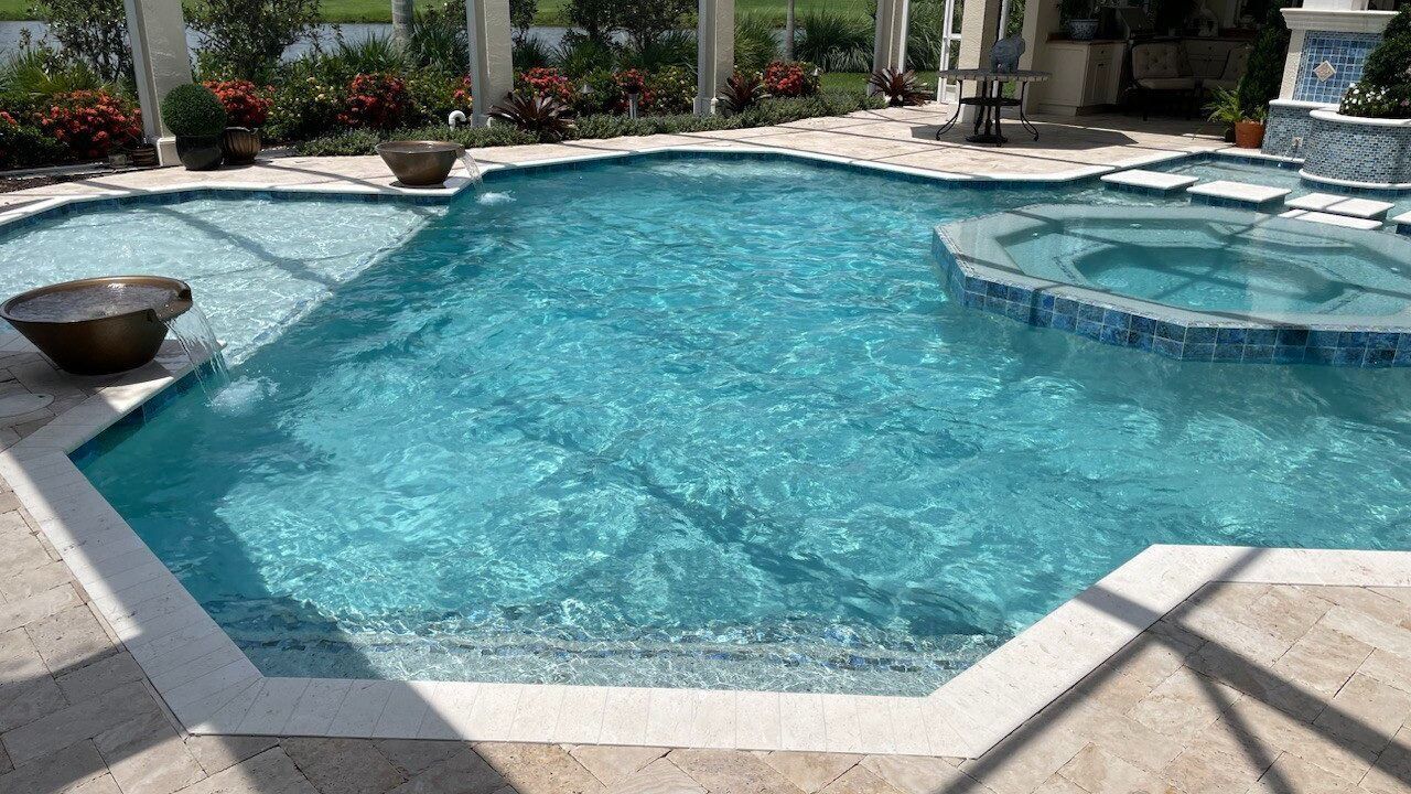 A large swimming pool with a hot tub in the middle of it.
