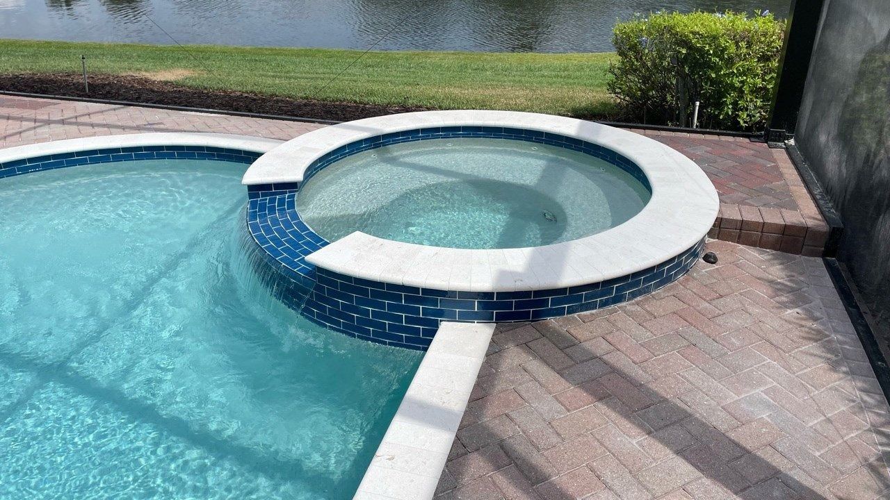 A swimming pool with a hot tub in the middle of it.