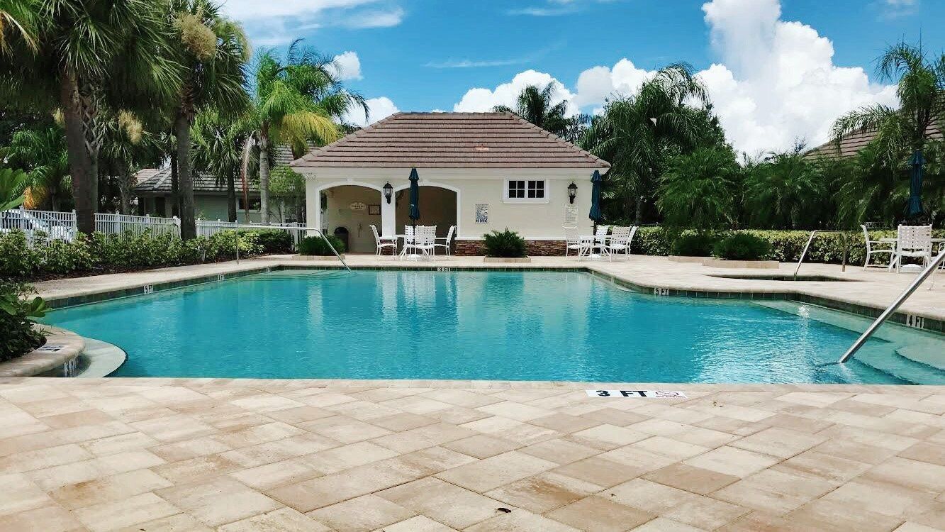 A large swimming pool with a white building in the background