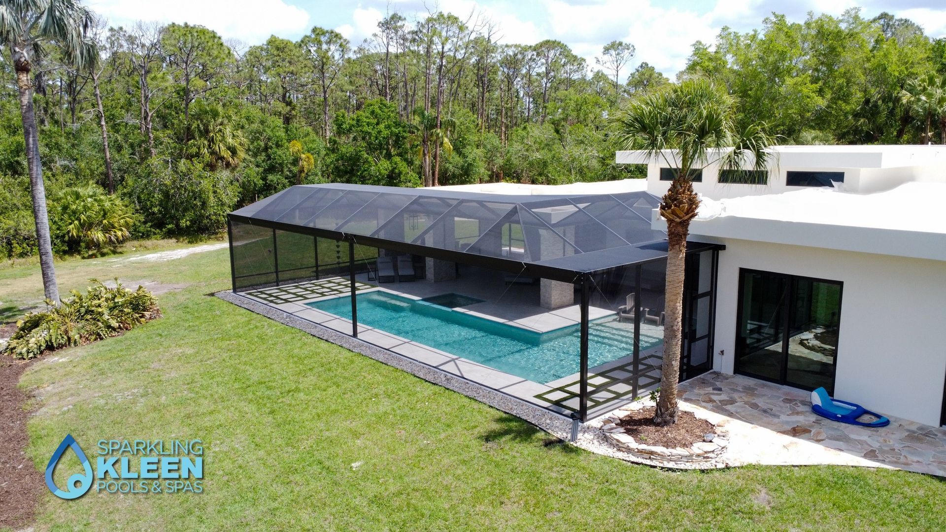 An aerial view of a house with a screened in pool.
