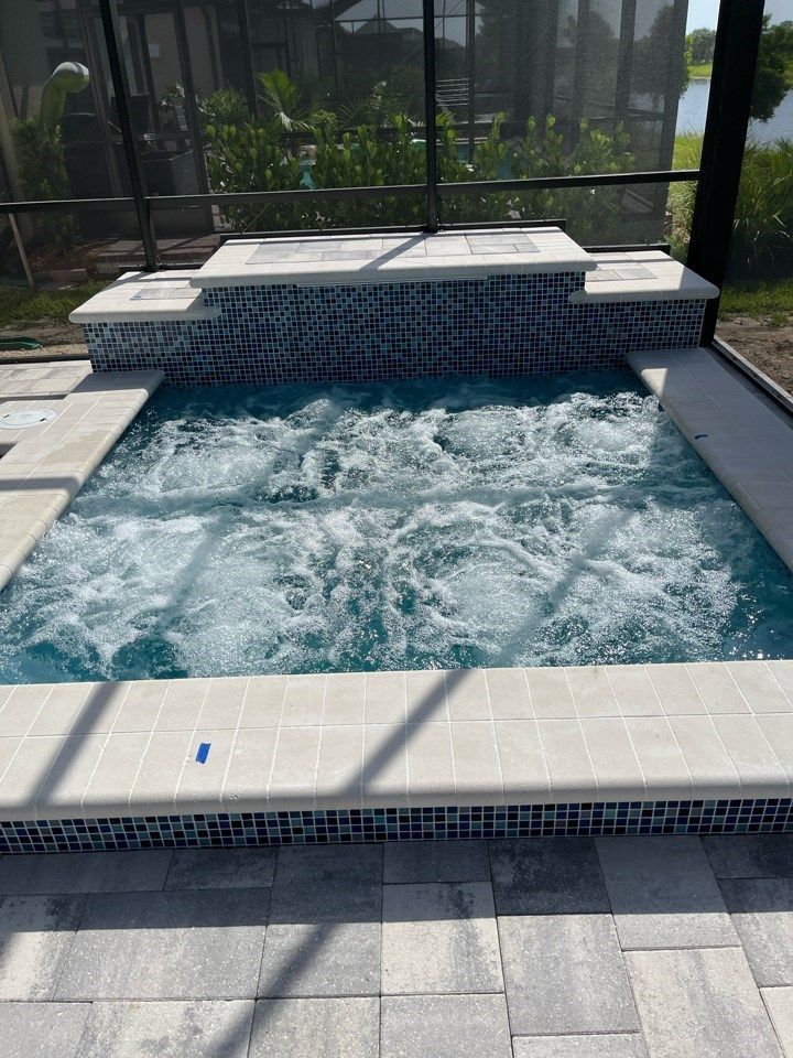 A large swimming pool with a jacuzzi in the middle of it.