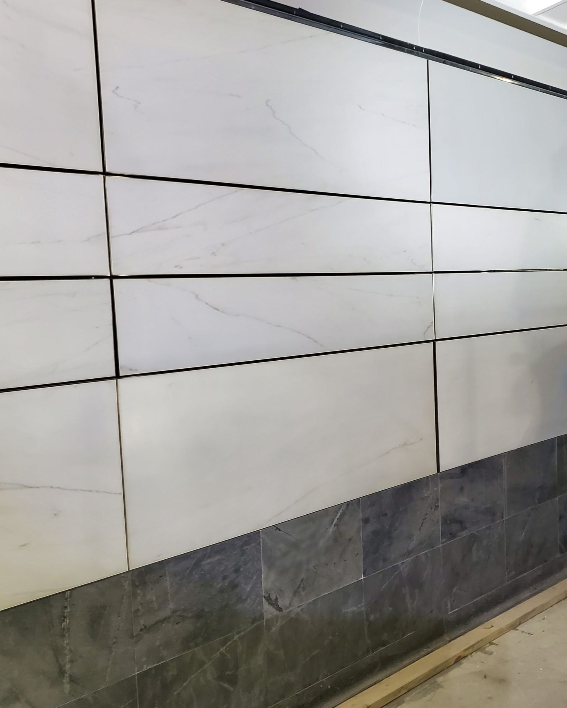 A wall with a lot of white tiles on it