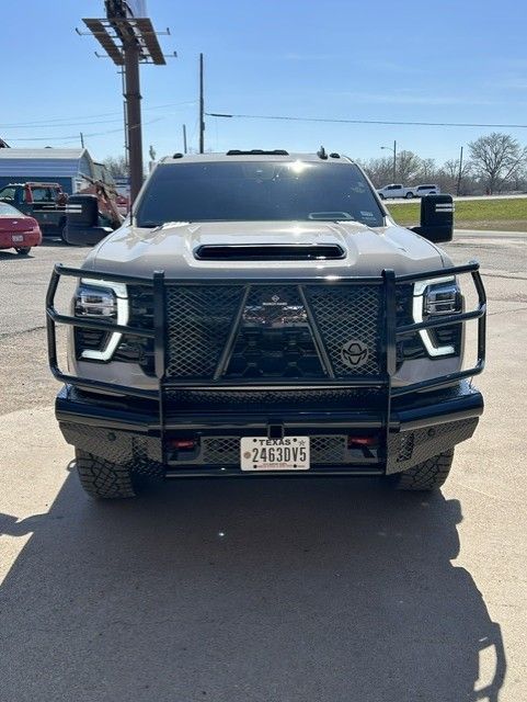 Front view of a black lifted pickup truck with a heavy grille guard parked in a sunny lot.