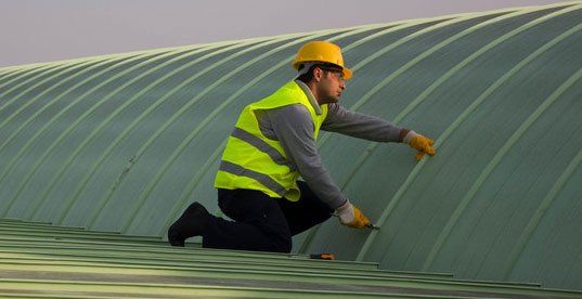 Man fixing the roof of commercial building