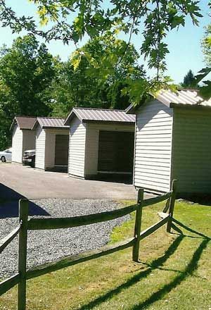 A row of storage sheds next to a wooden fence.