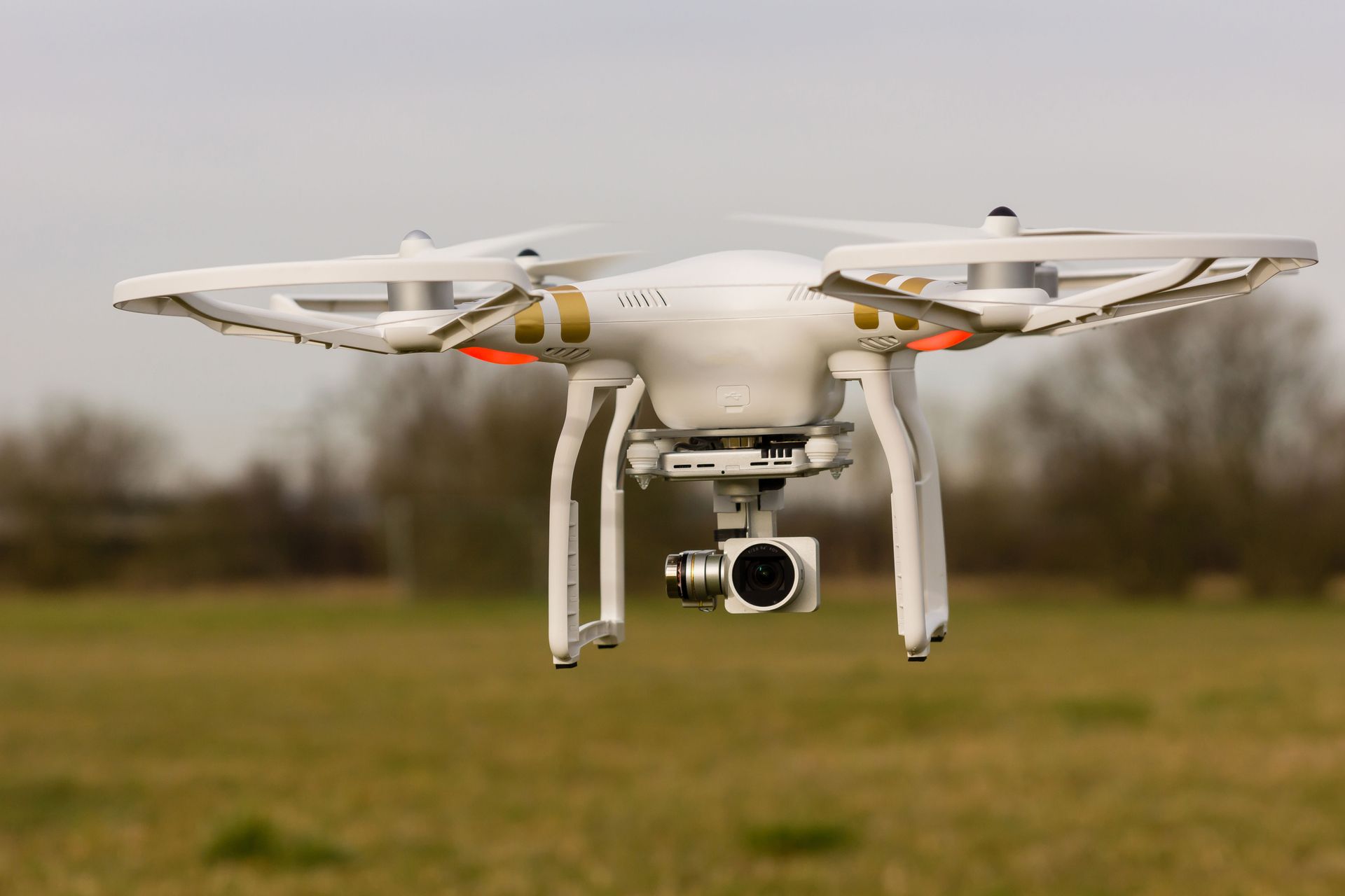A drone with a camera is flying over a field.