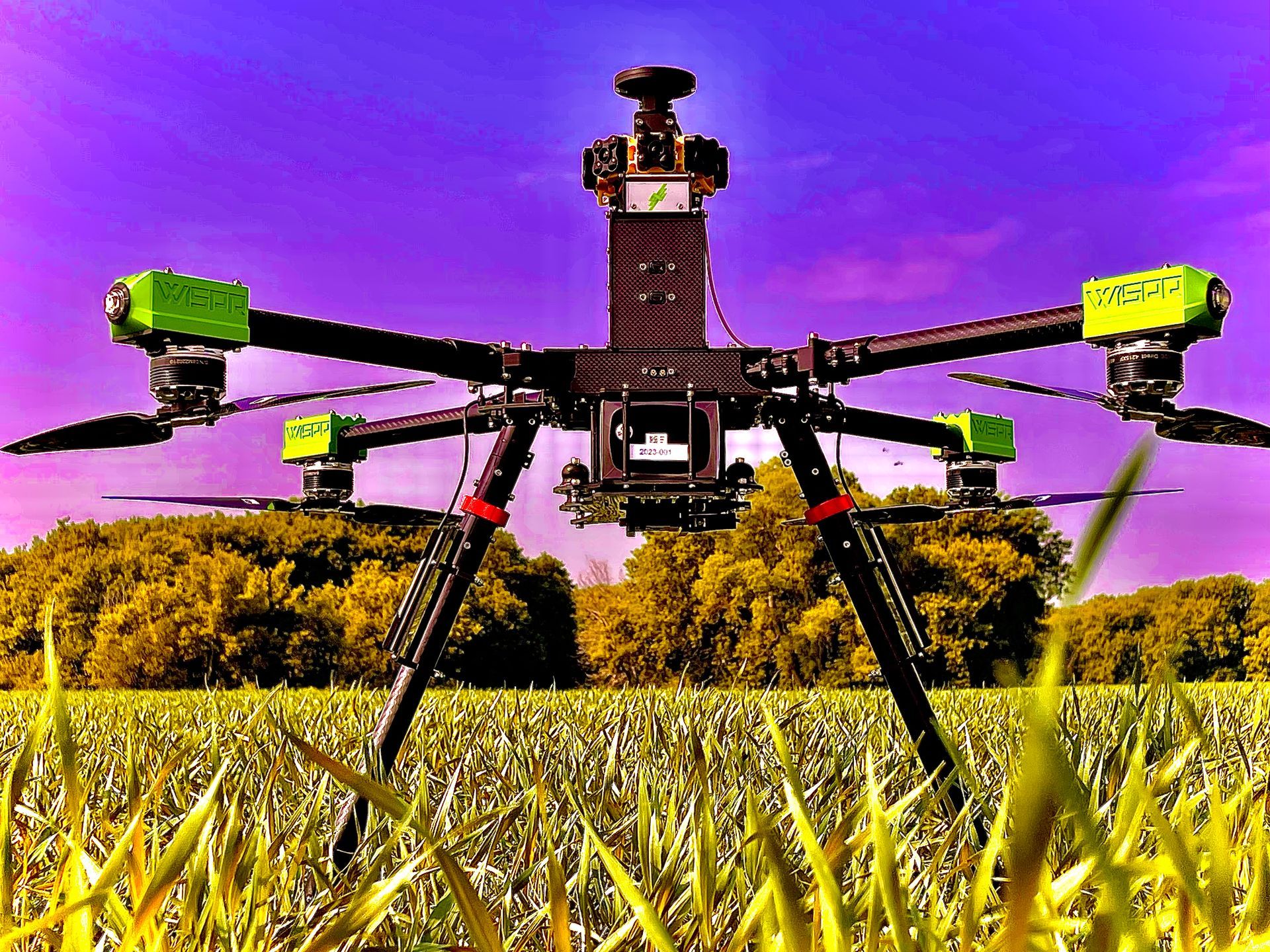 A drone is sitting in the middle of a grassy field.