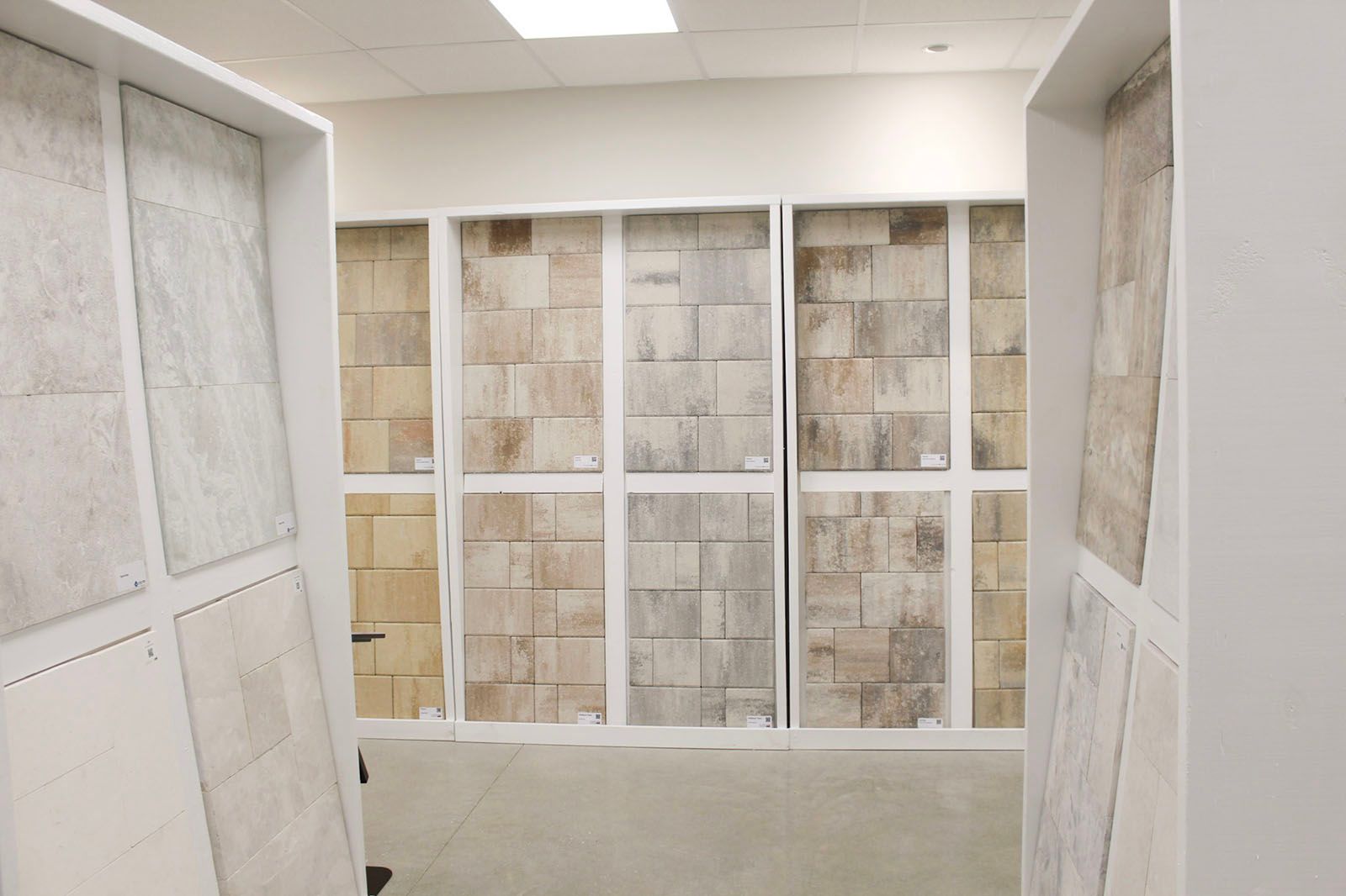 A room with white walls and tiled display panels under bright ceiling lights
