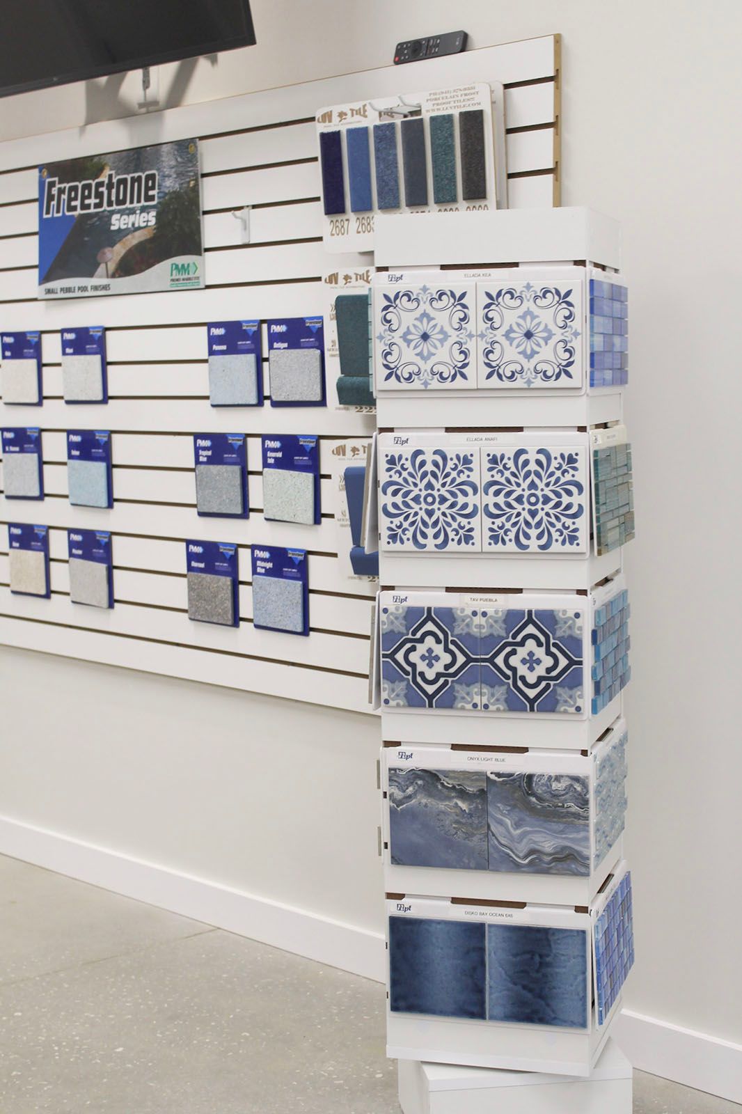 Tile display wall with stacked blue-and-white decorative tile samples in a showroom