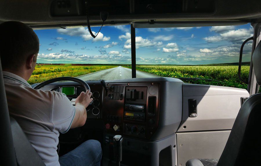 A man is driving a semi truck down a country road.