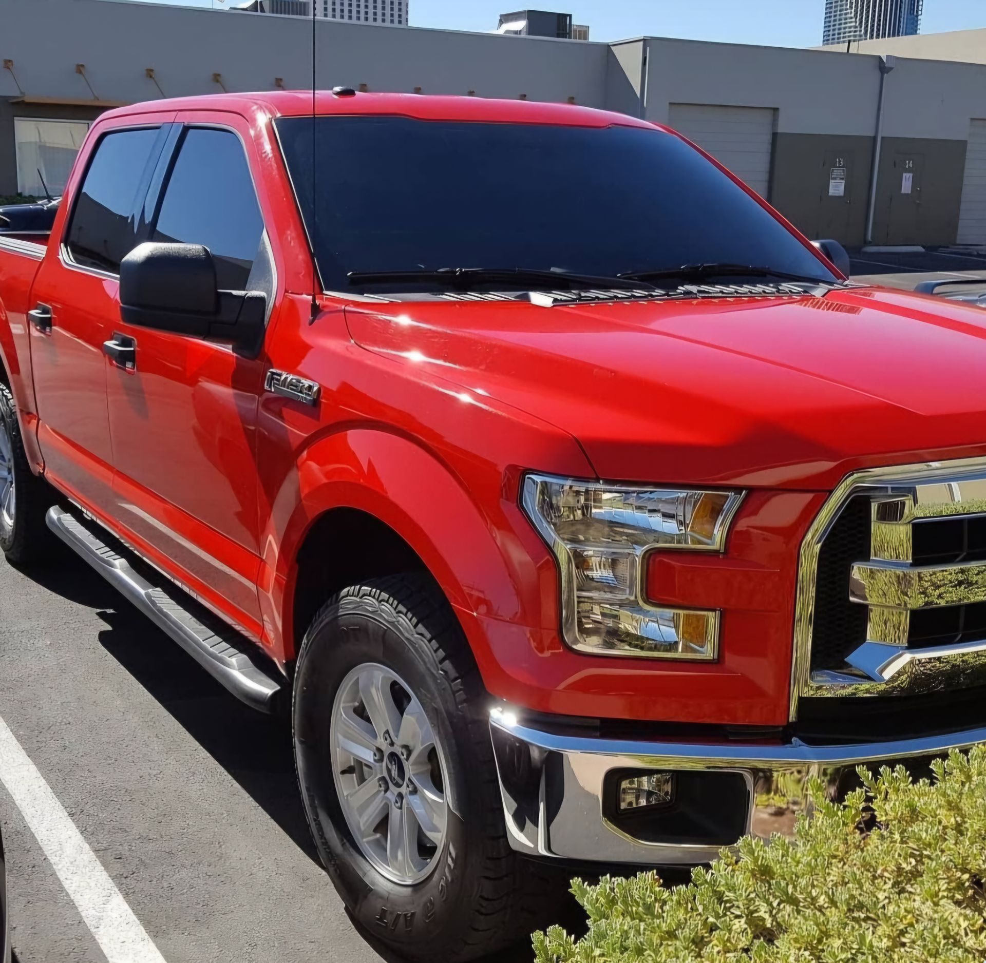 A red ford truck is parked in a parking lot