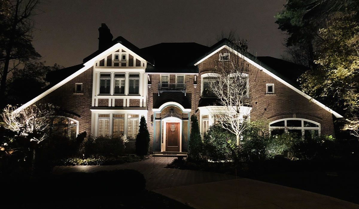 A large brick house is lit up at night.