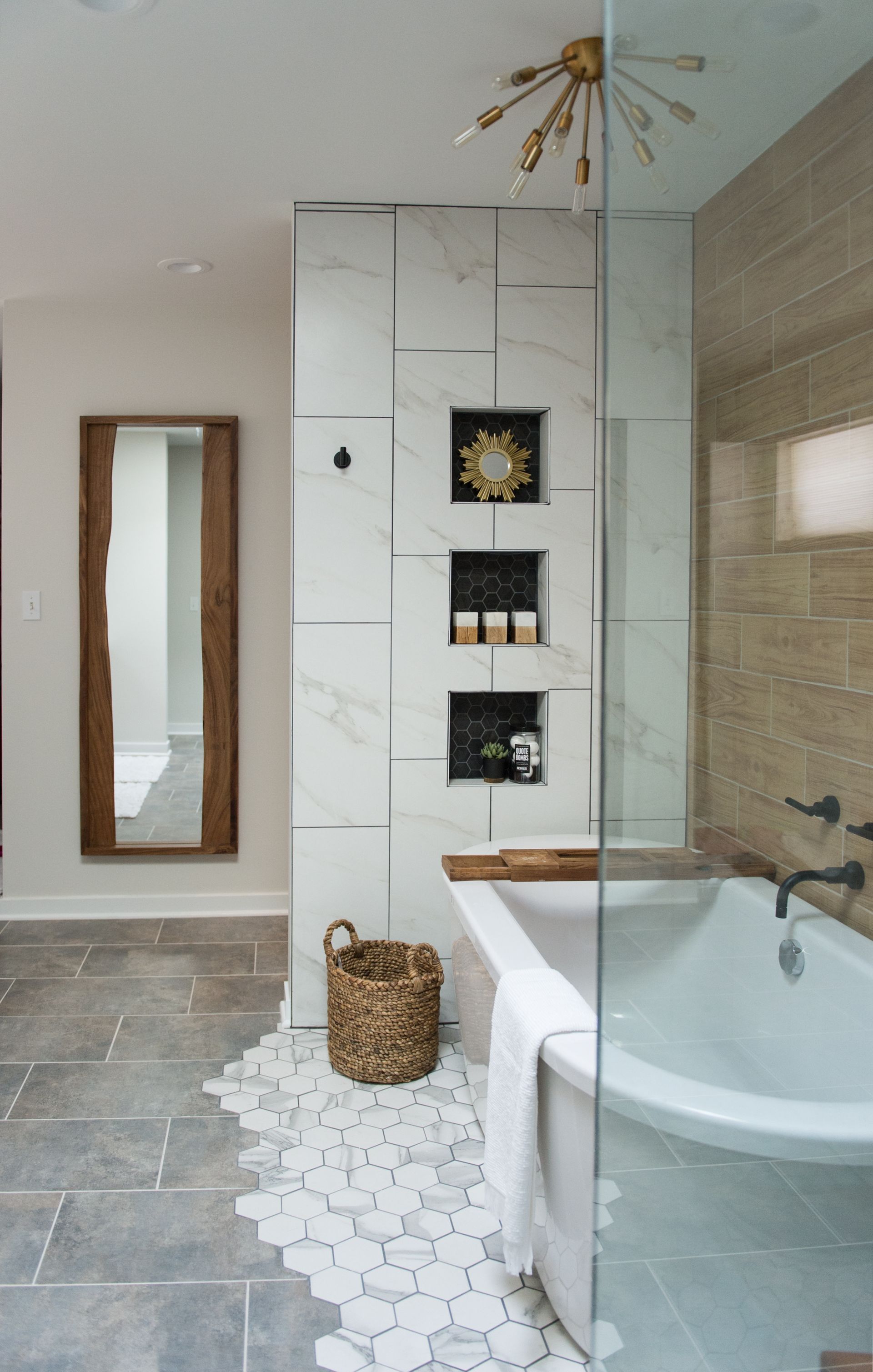 Modern bathroom with freestanding tub, tiled shower, and wall mirror in a light neutral interior