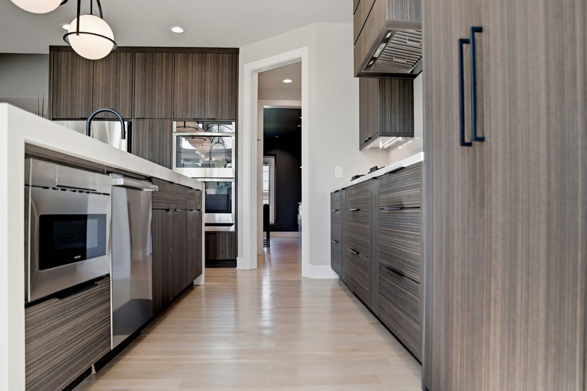 Modern kitchen with wood cabinets, stainless appliances, and a long island under bright lighting