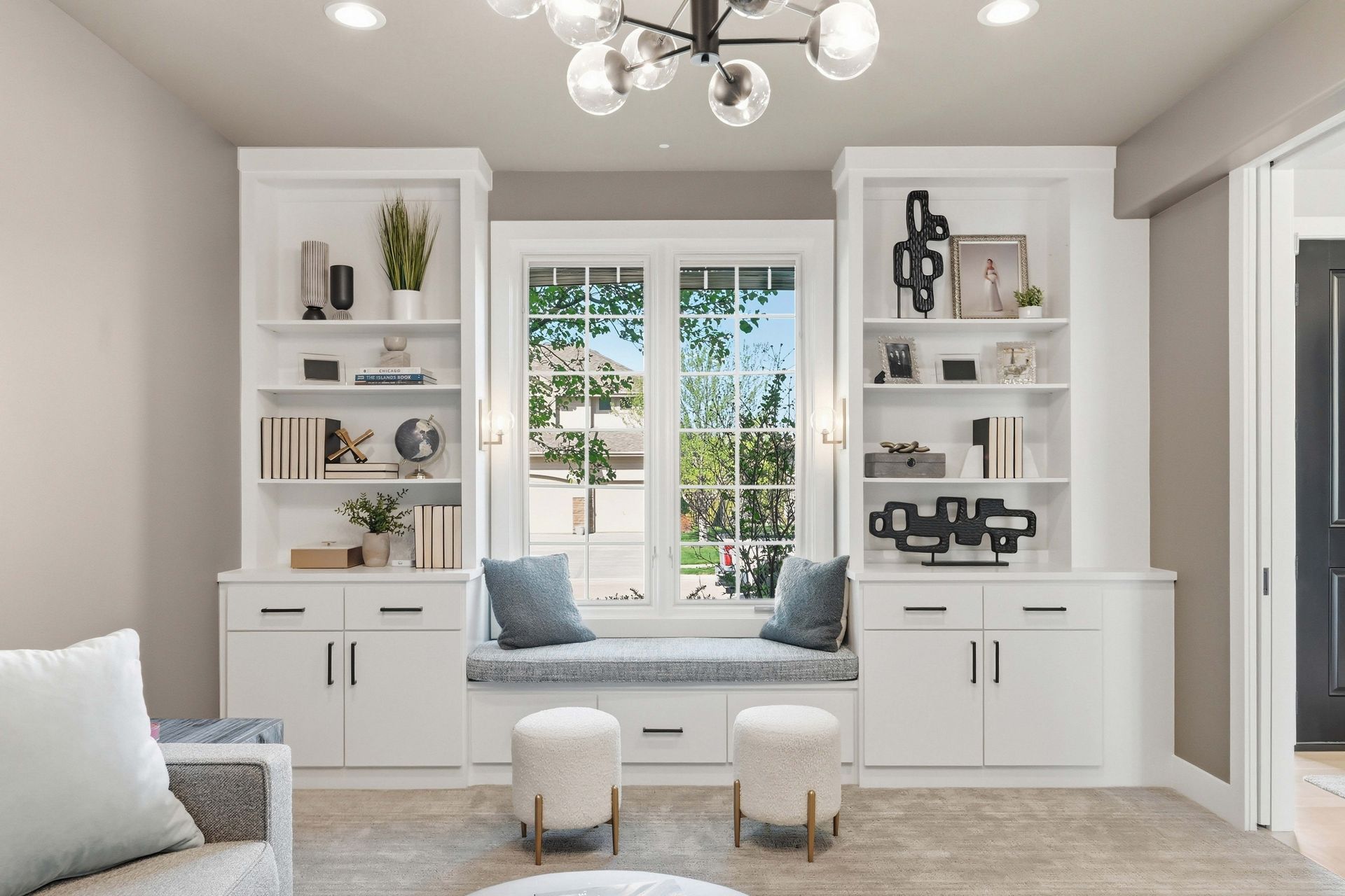 Bright living room with built-in shelves, a window seat, and neutral decor