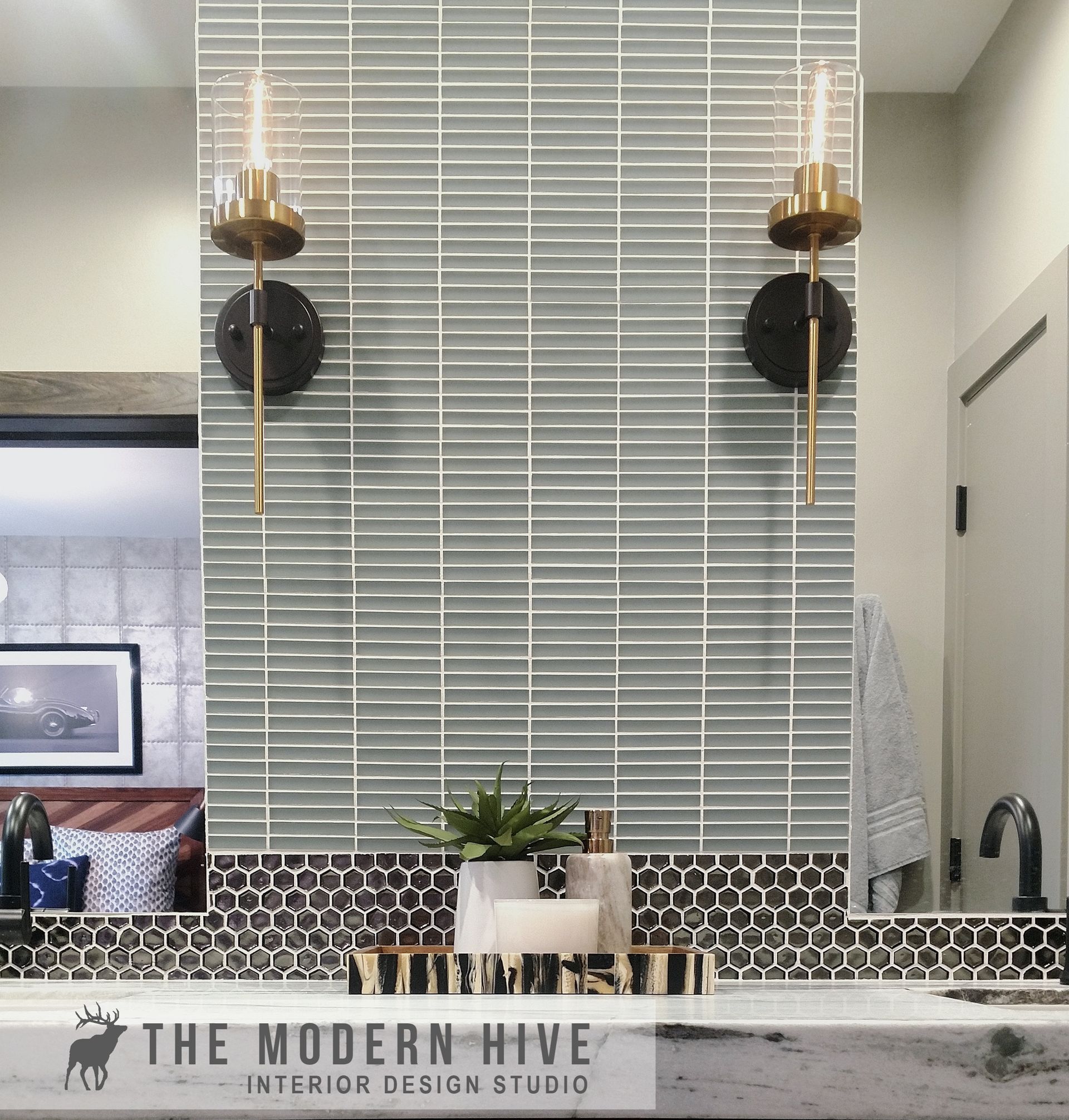 Modern bathroom vanity with gray tile backsplash, white countertop, and gold wall sconces