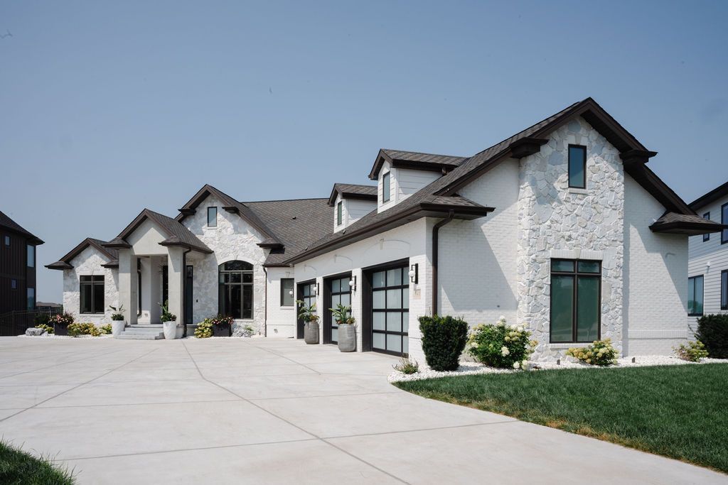 Row of modern white suburban houses with gray roofs and a wide concrete driveway