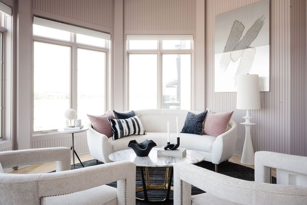 Bright living room with white sofa, large windows, and black-and-white decor.