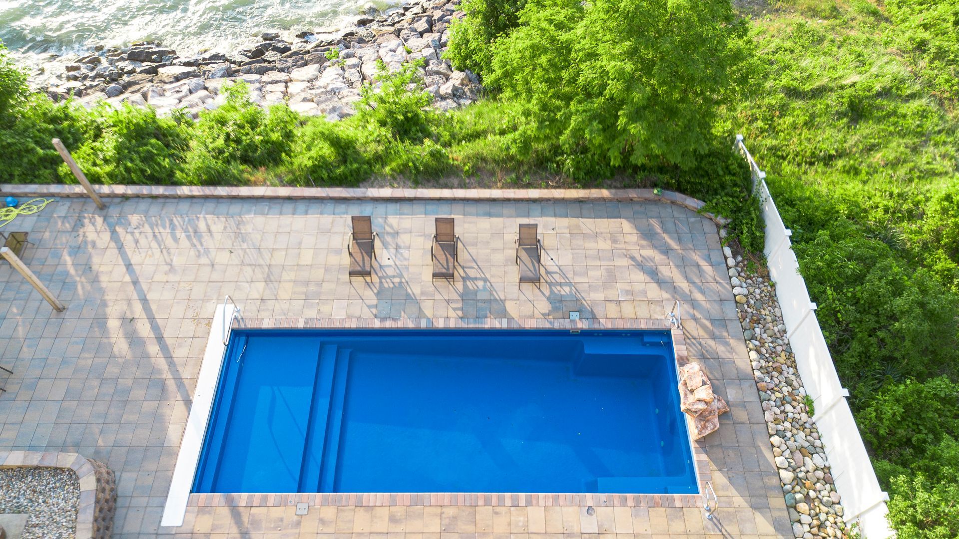 An aerial view of a large swimming pool surrounded by trees.