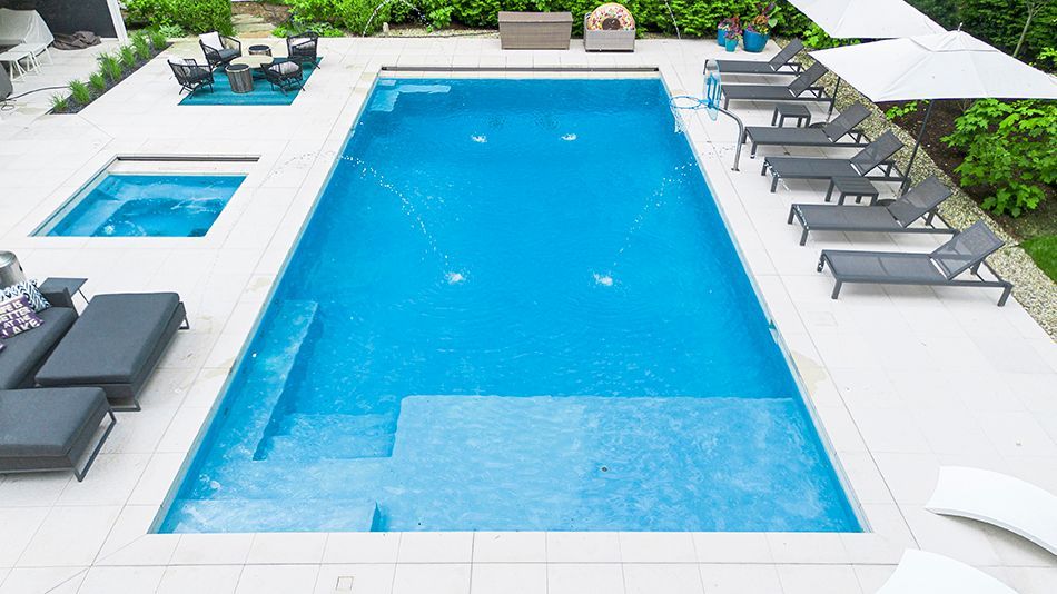 An aerial view of a large swimming pool surrounded by chairs and umbrellas.